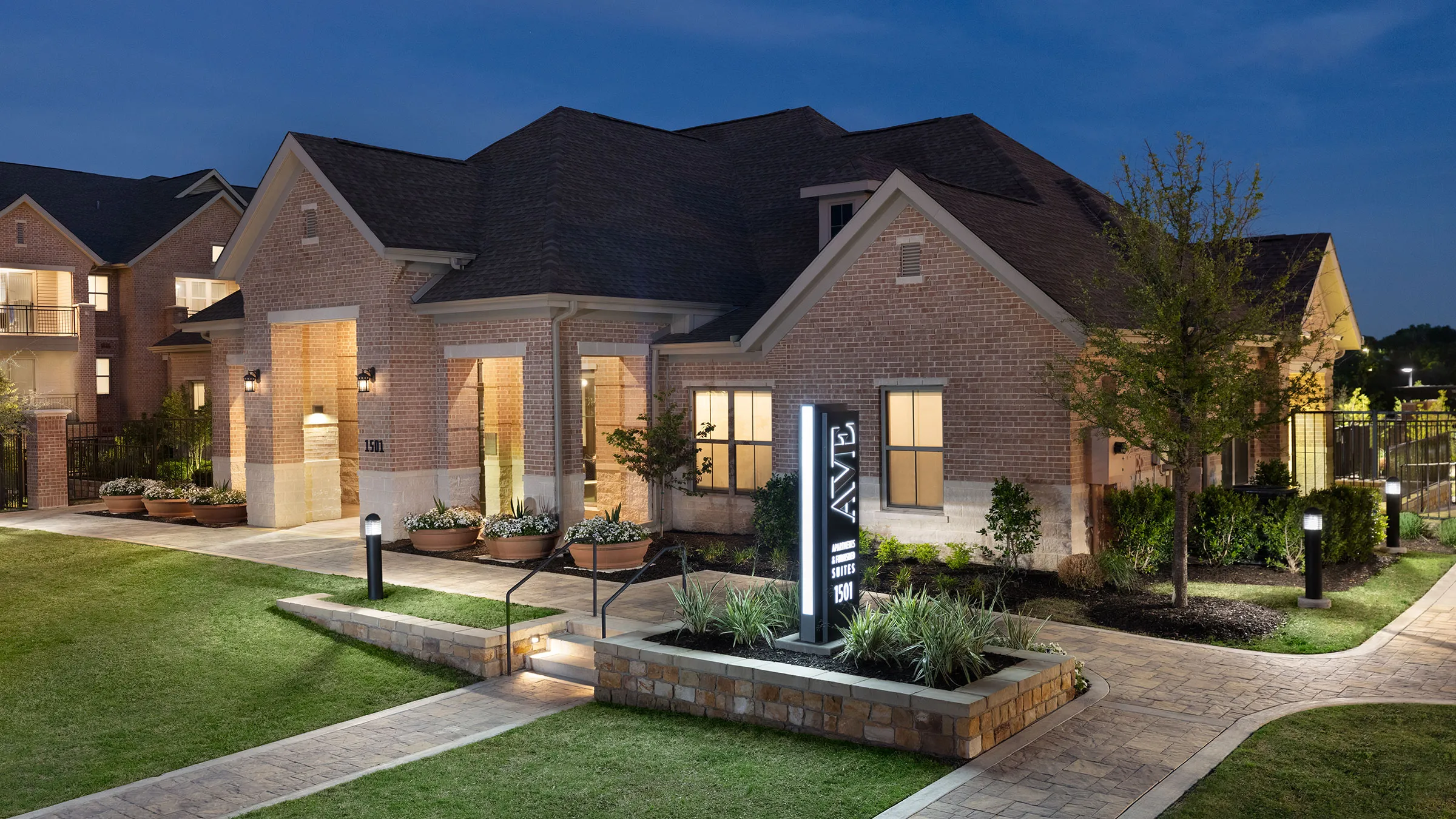 a brick house with a lawn and a sign