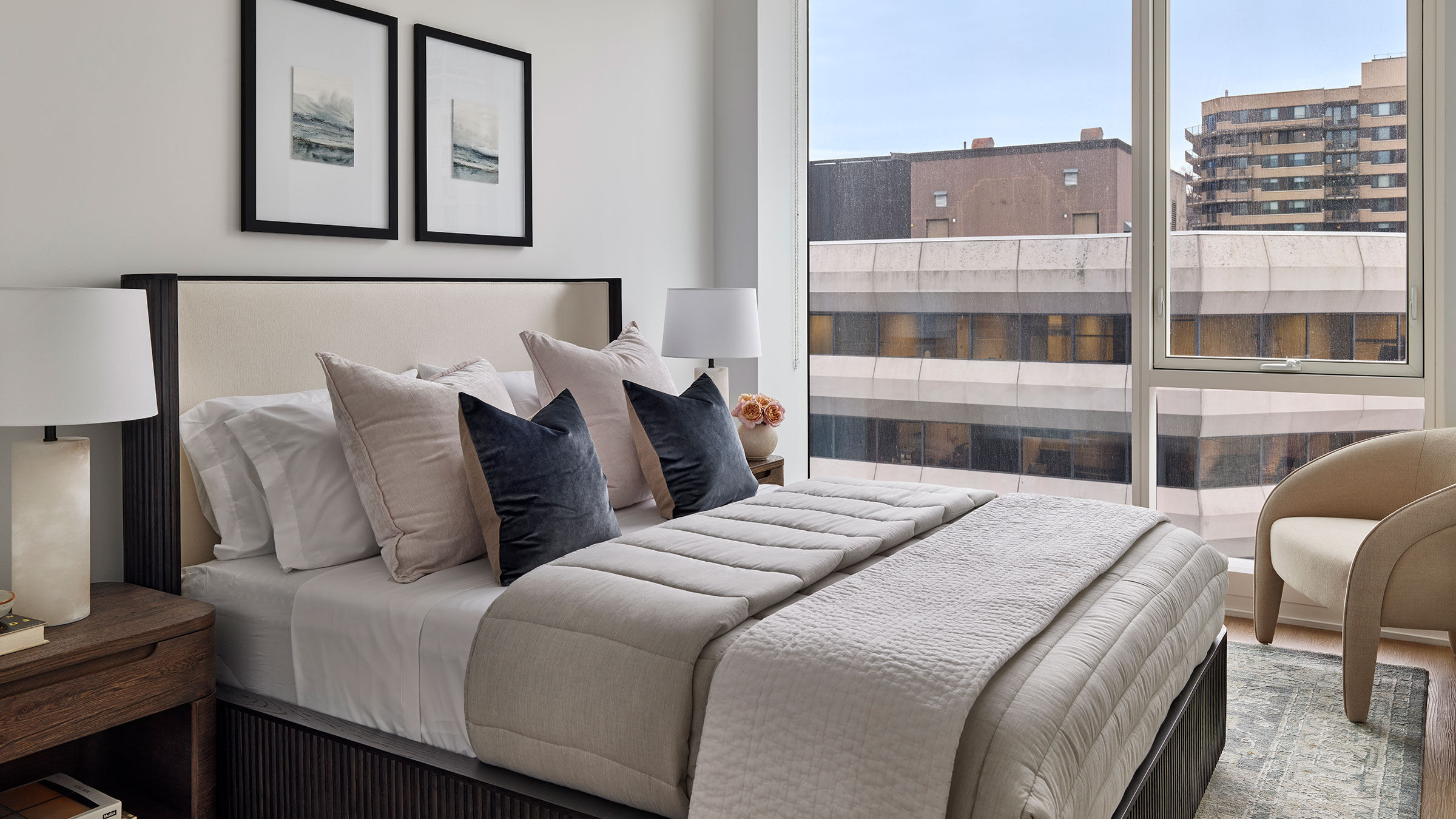 a bed with pillows and a lamp in a room with a window