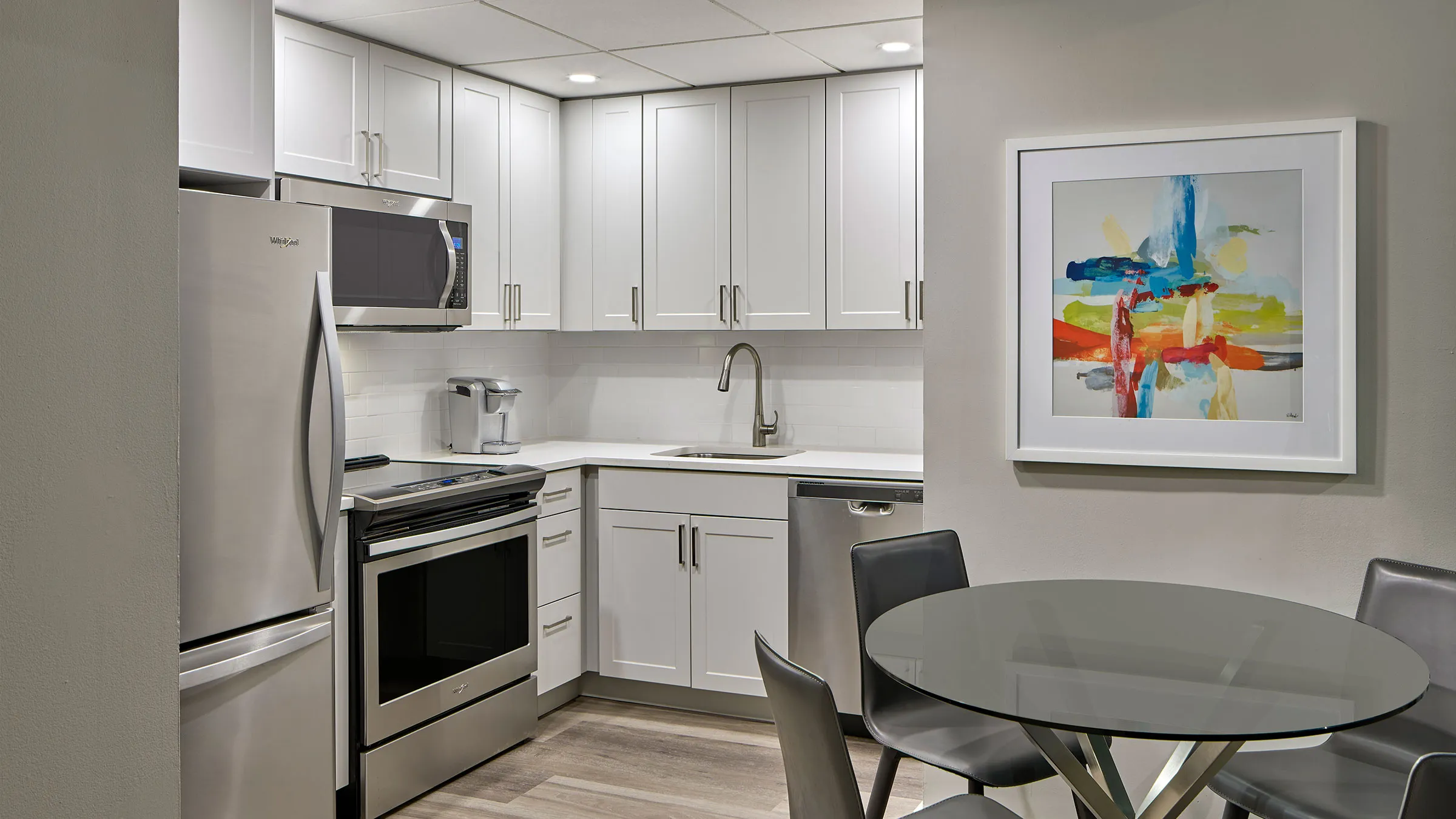 a kitchen with white cabinets and a table