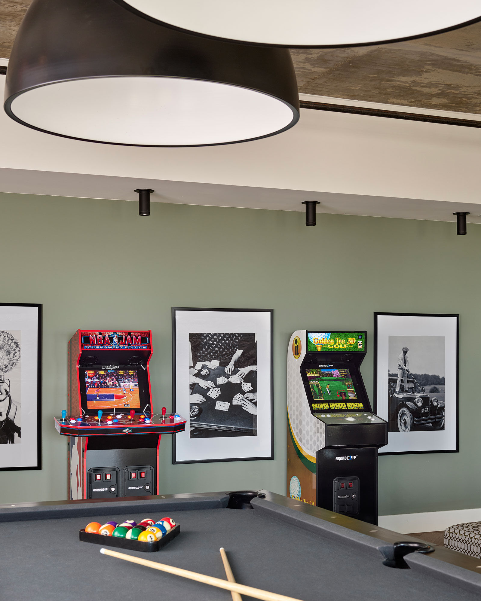a room with a pool table and arcade game