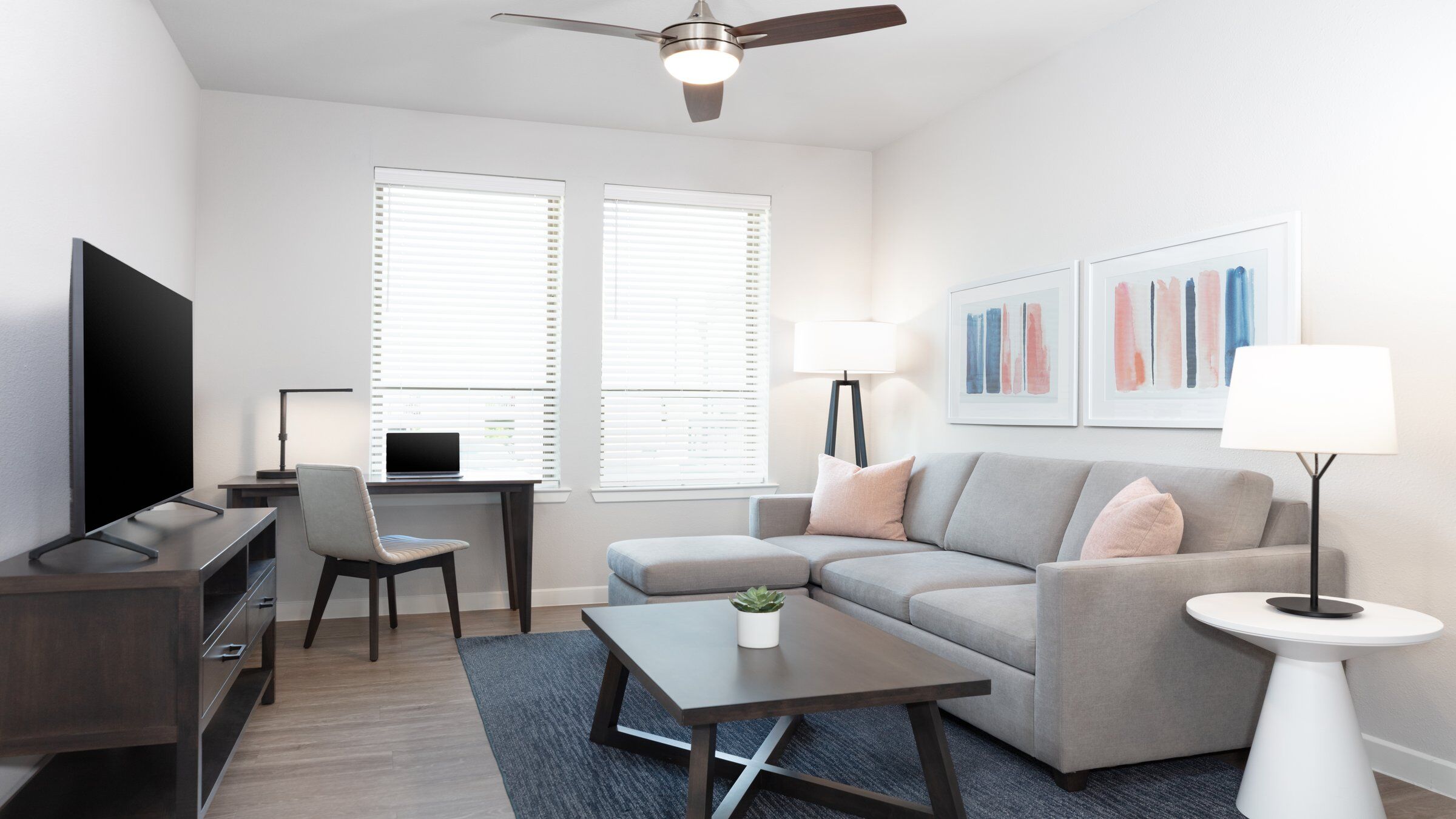 an apartment living room with a couch and a desk