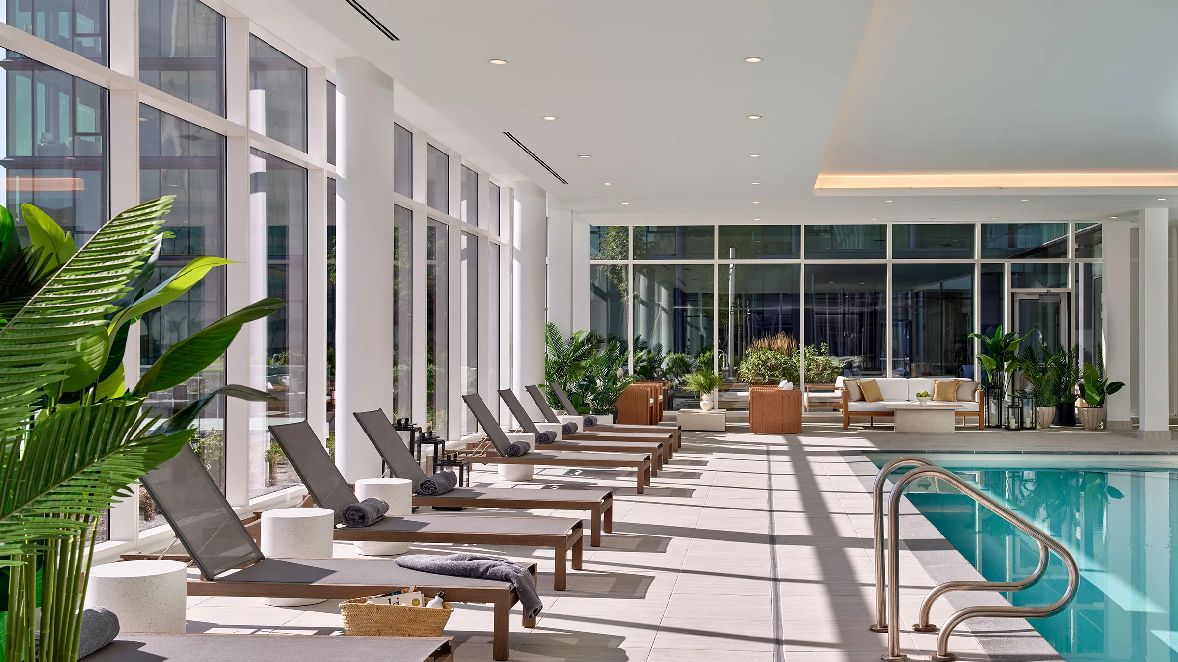 a pool with chairs and a large window