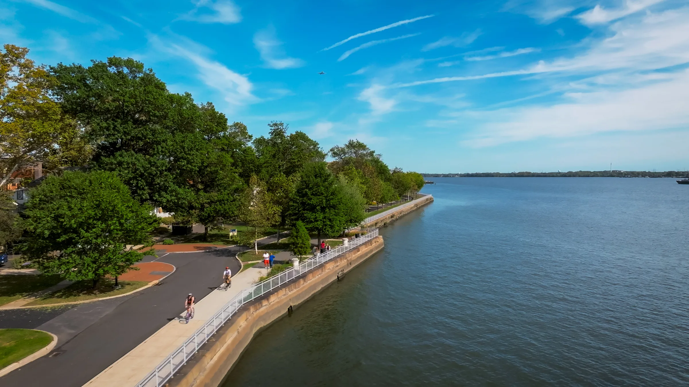 a body of water with trees and a path