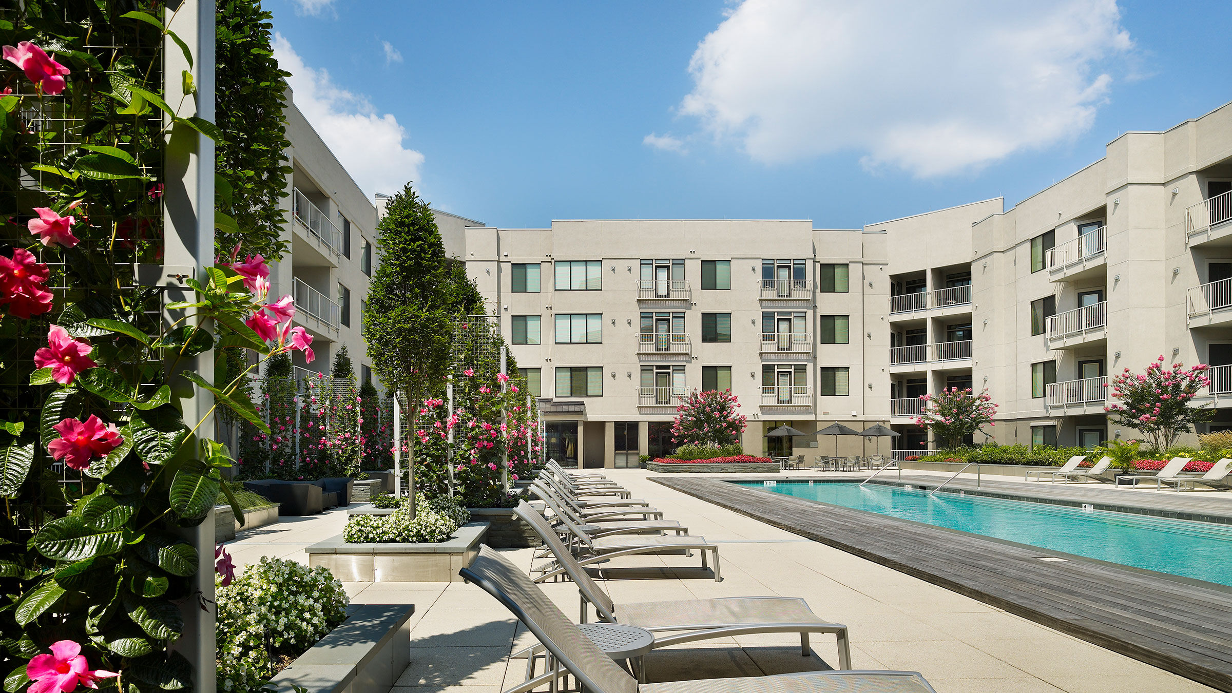 a pool and chairs in front of a building