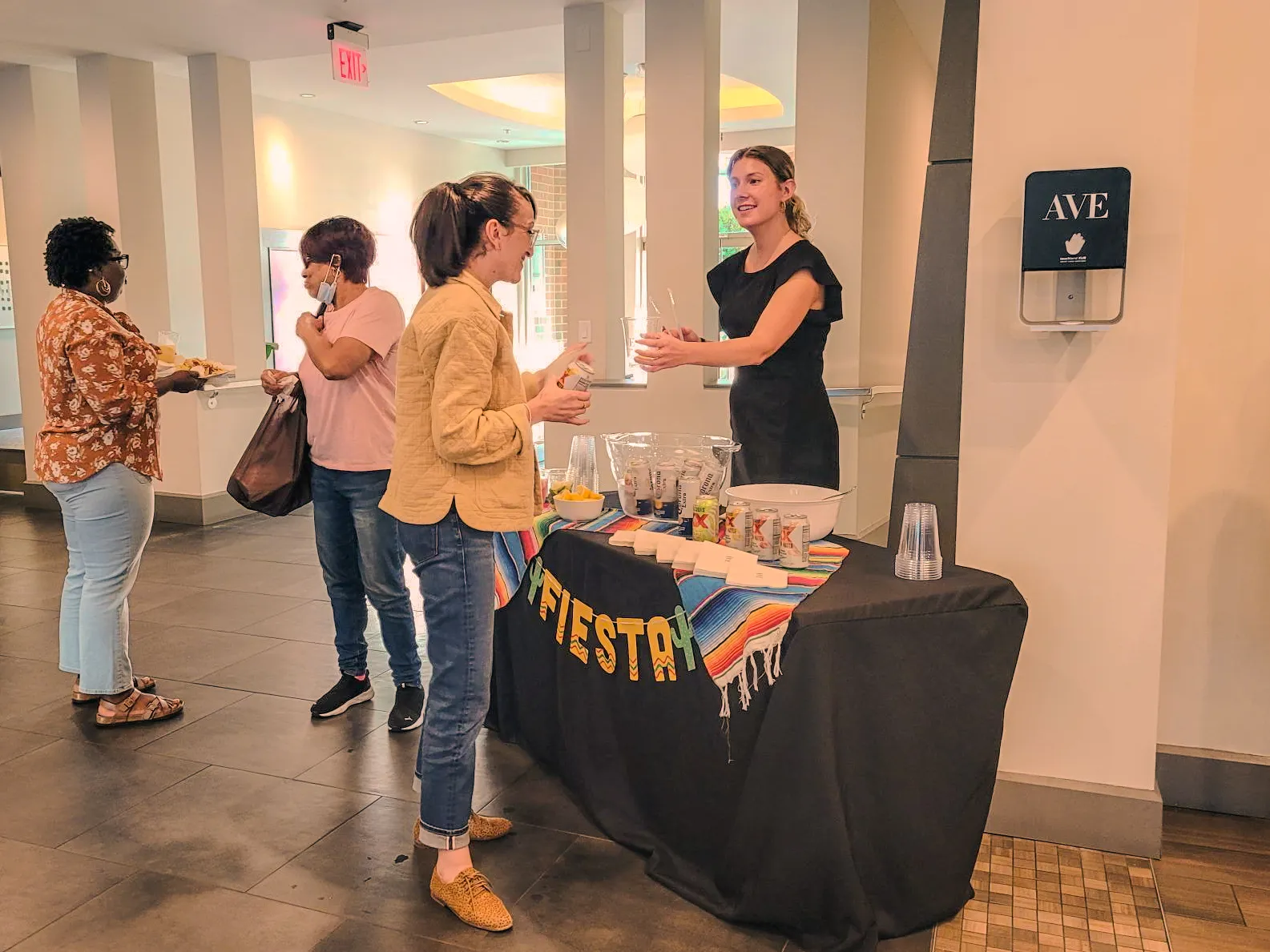 a group of people standing around a table with drinks