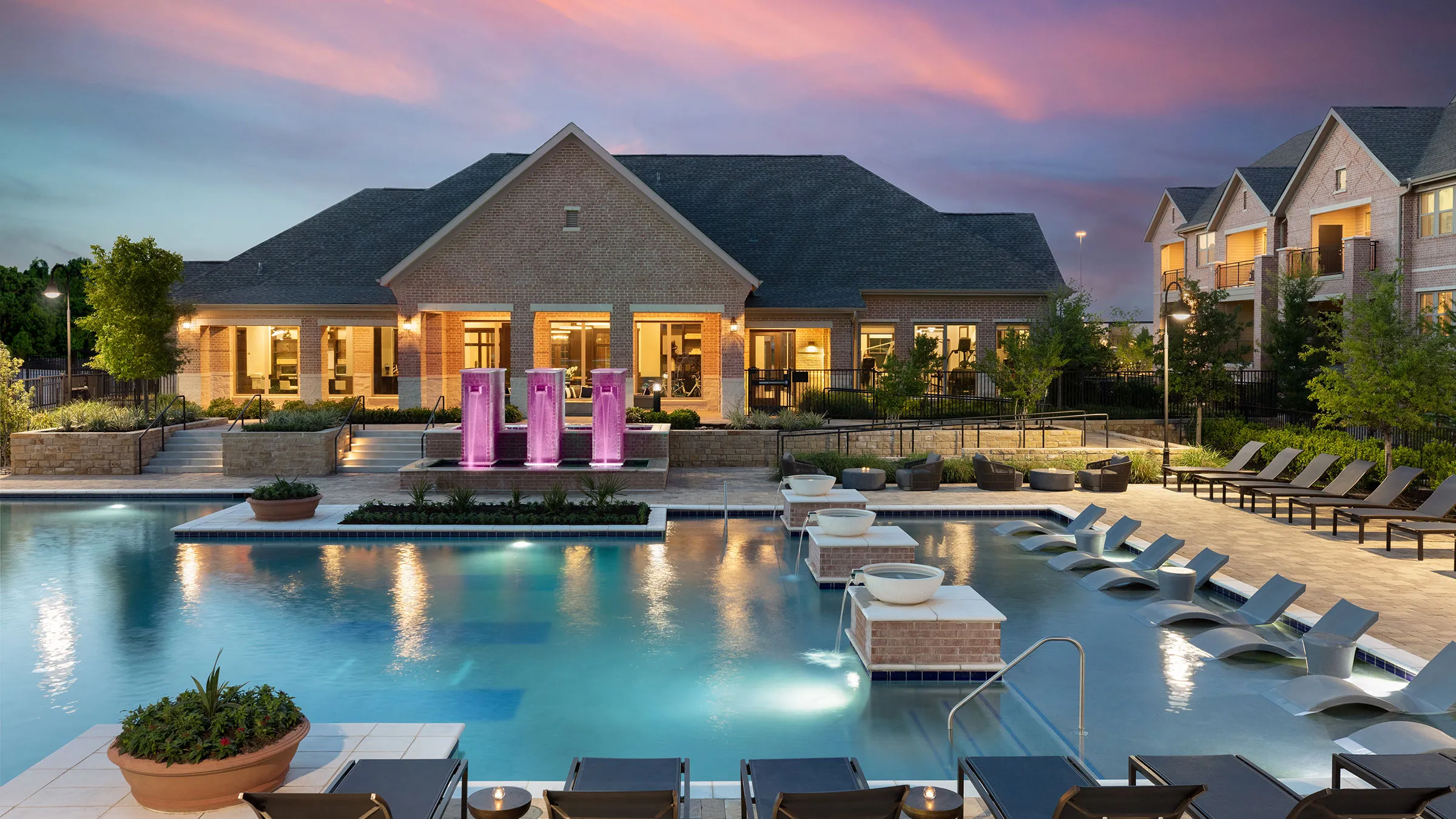 a pool with chairs and a building in the background