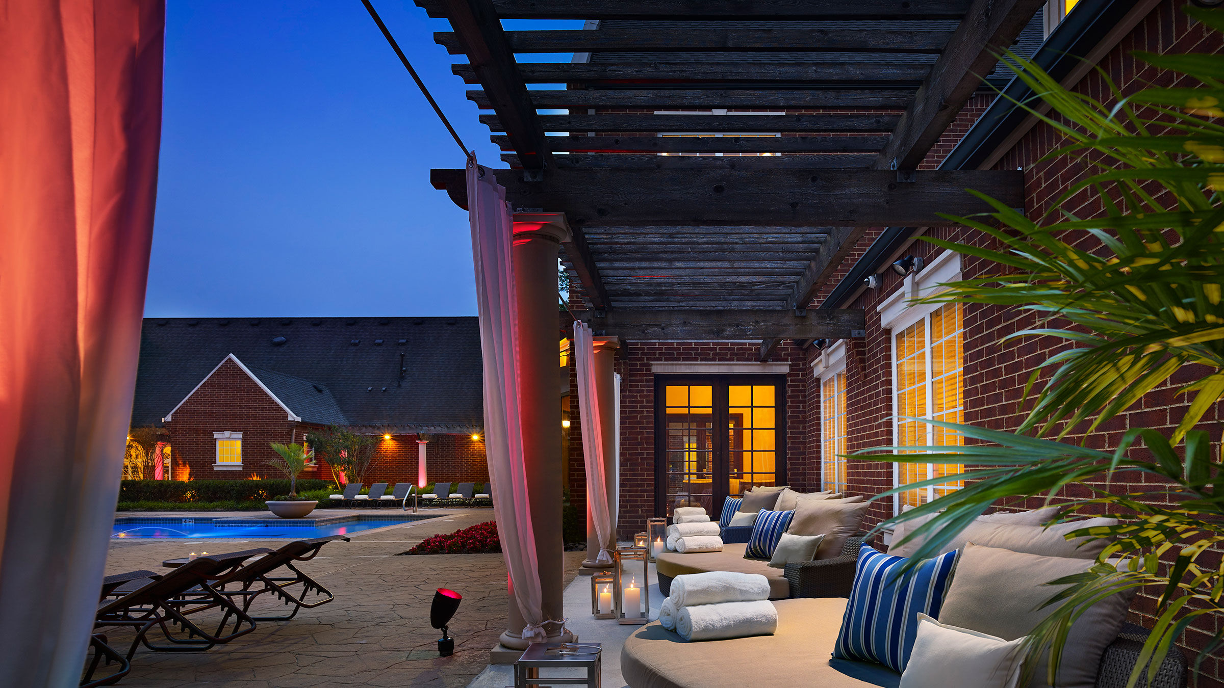 a patio with a pool and lounge chairs