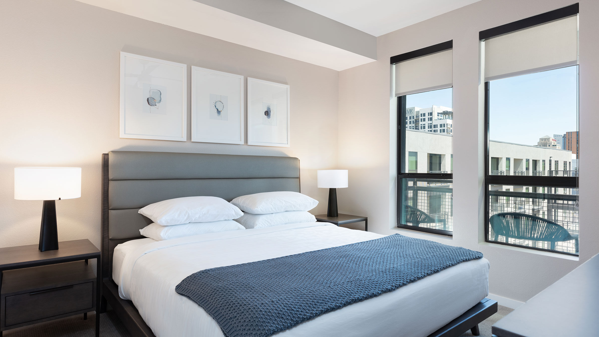 a bed with a blue blanket and a lamp