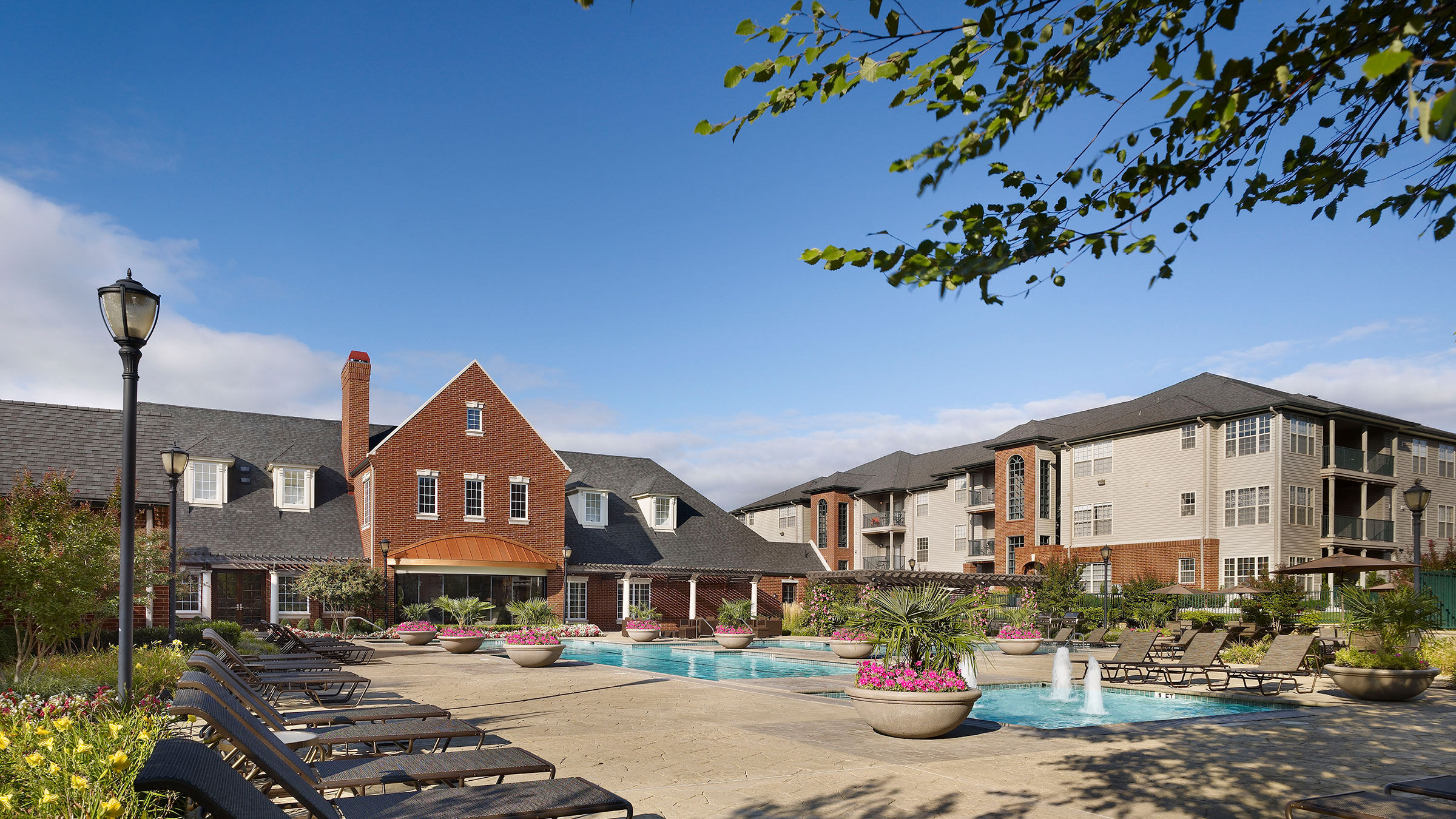 a pool with lounge chairs and a building in the background
