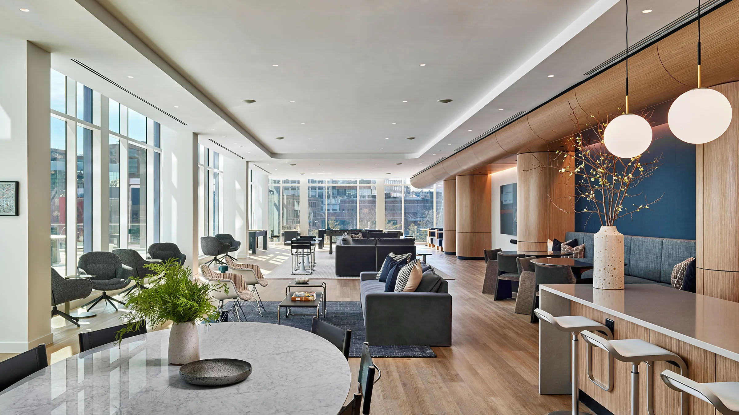 a room with a large window and a table with chairs and a plant