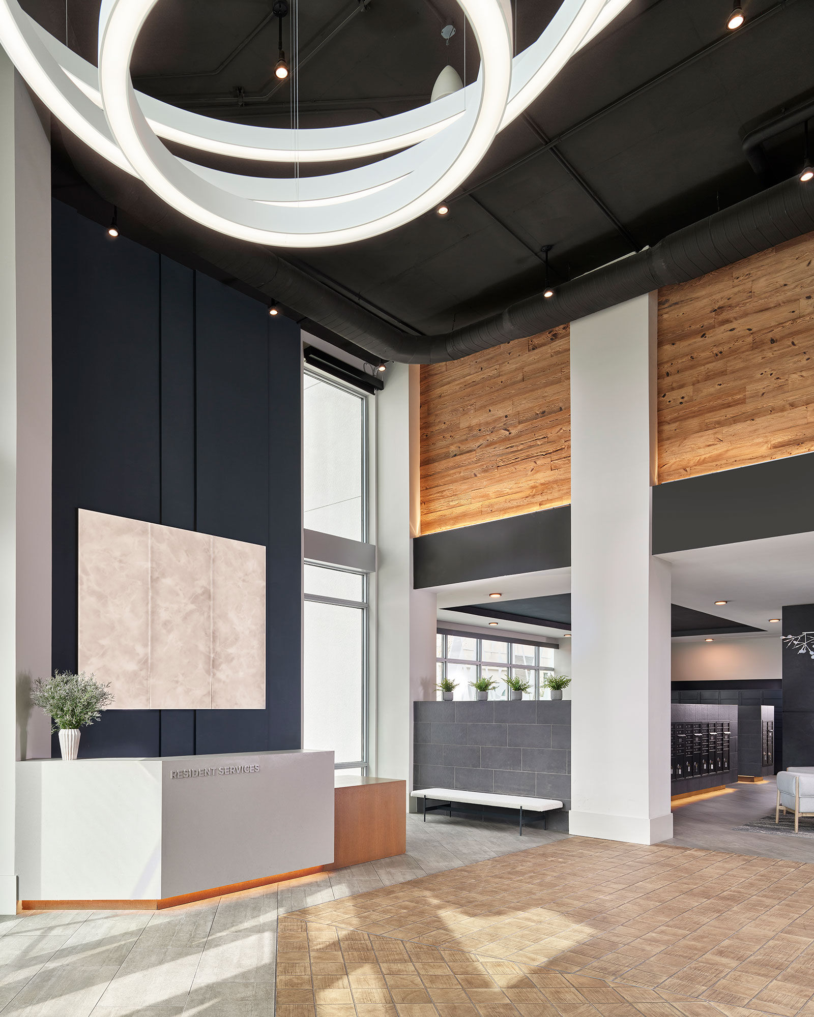 a lobby with a large white counter and a black ceiling