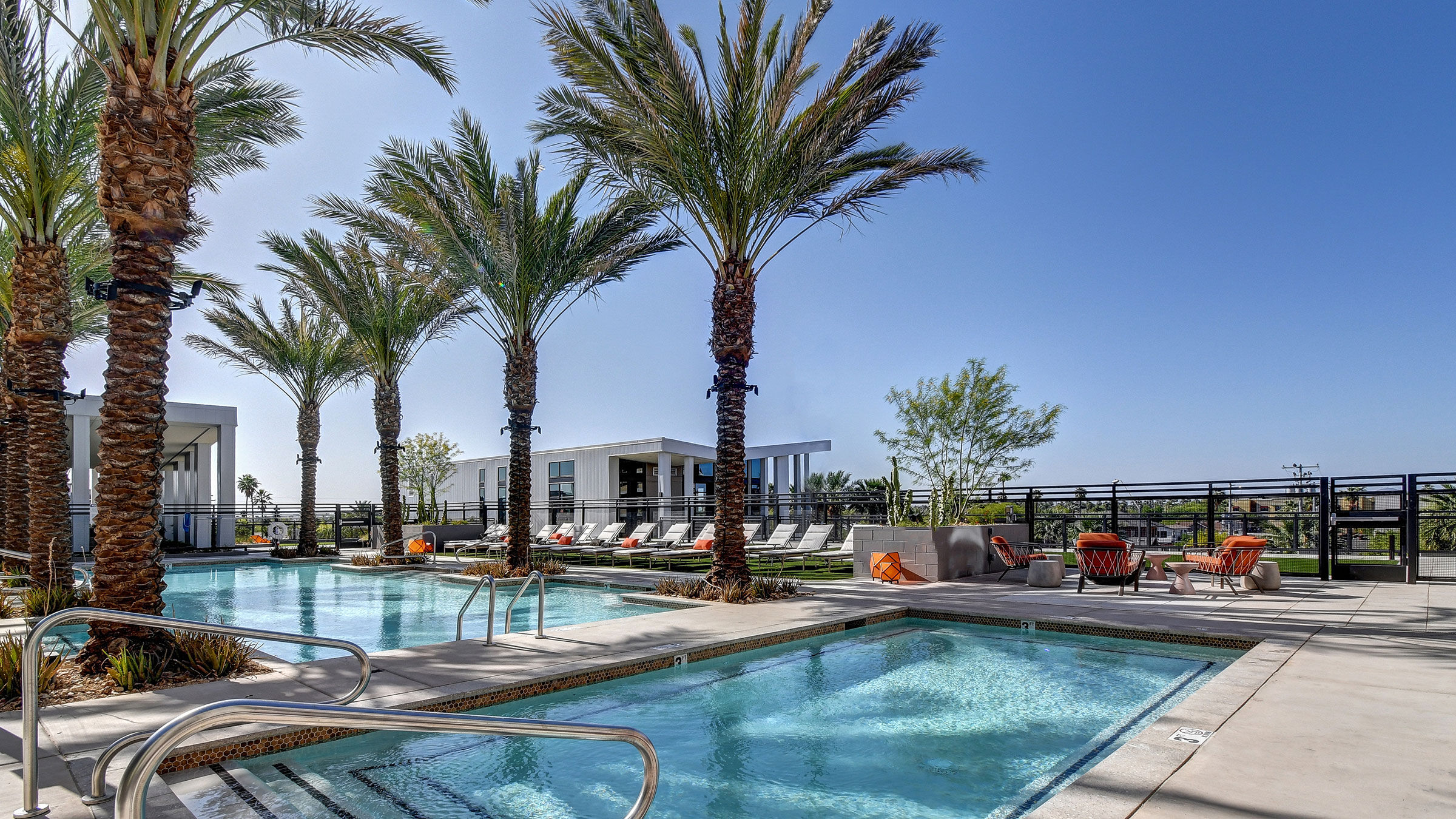 a pool with palm trees and a building