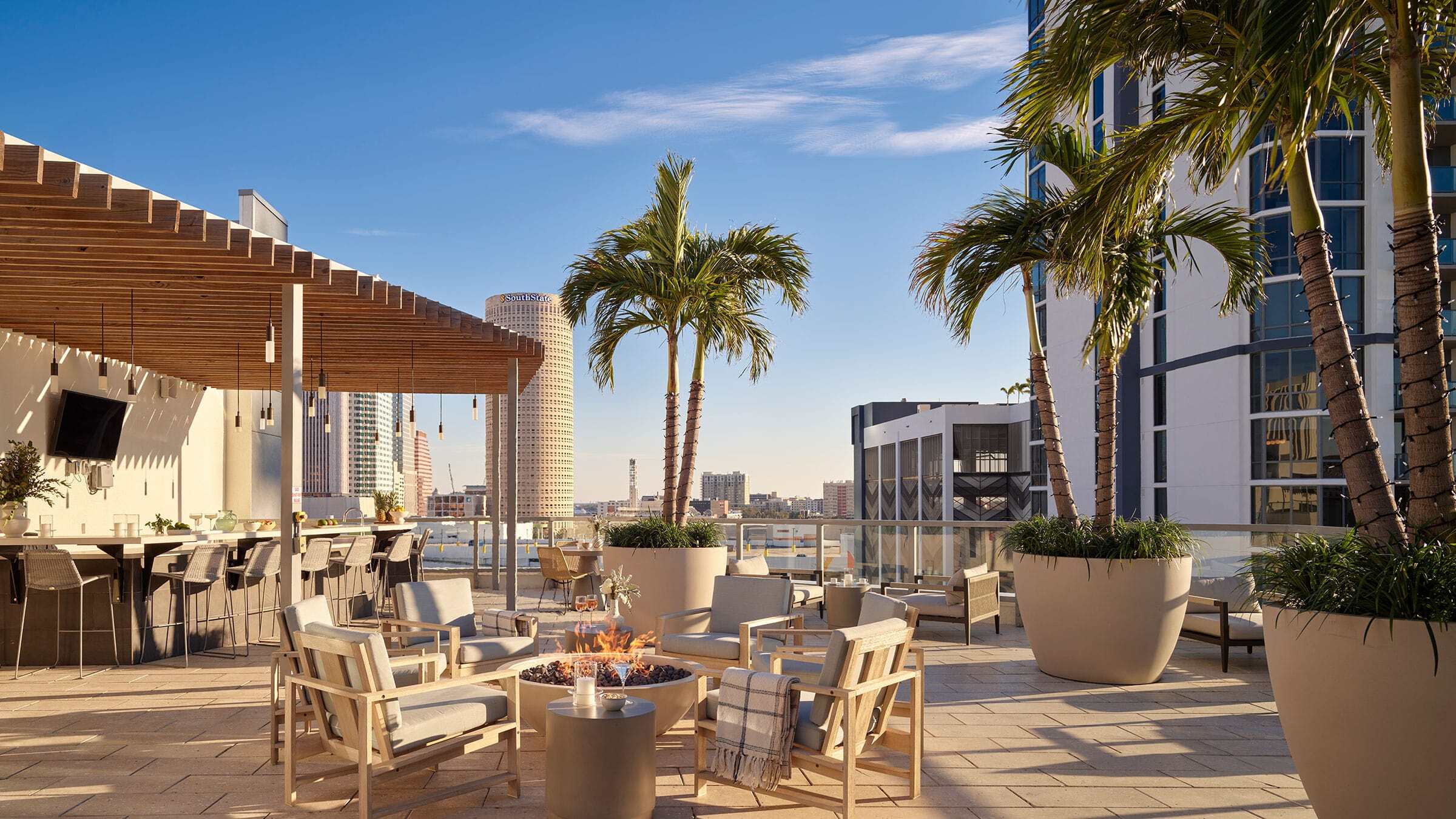 a patio with chairs and a fire pit on a rooftop
