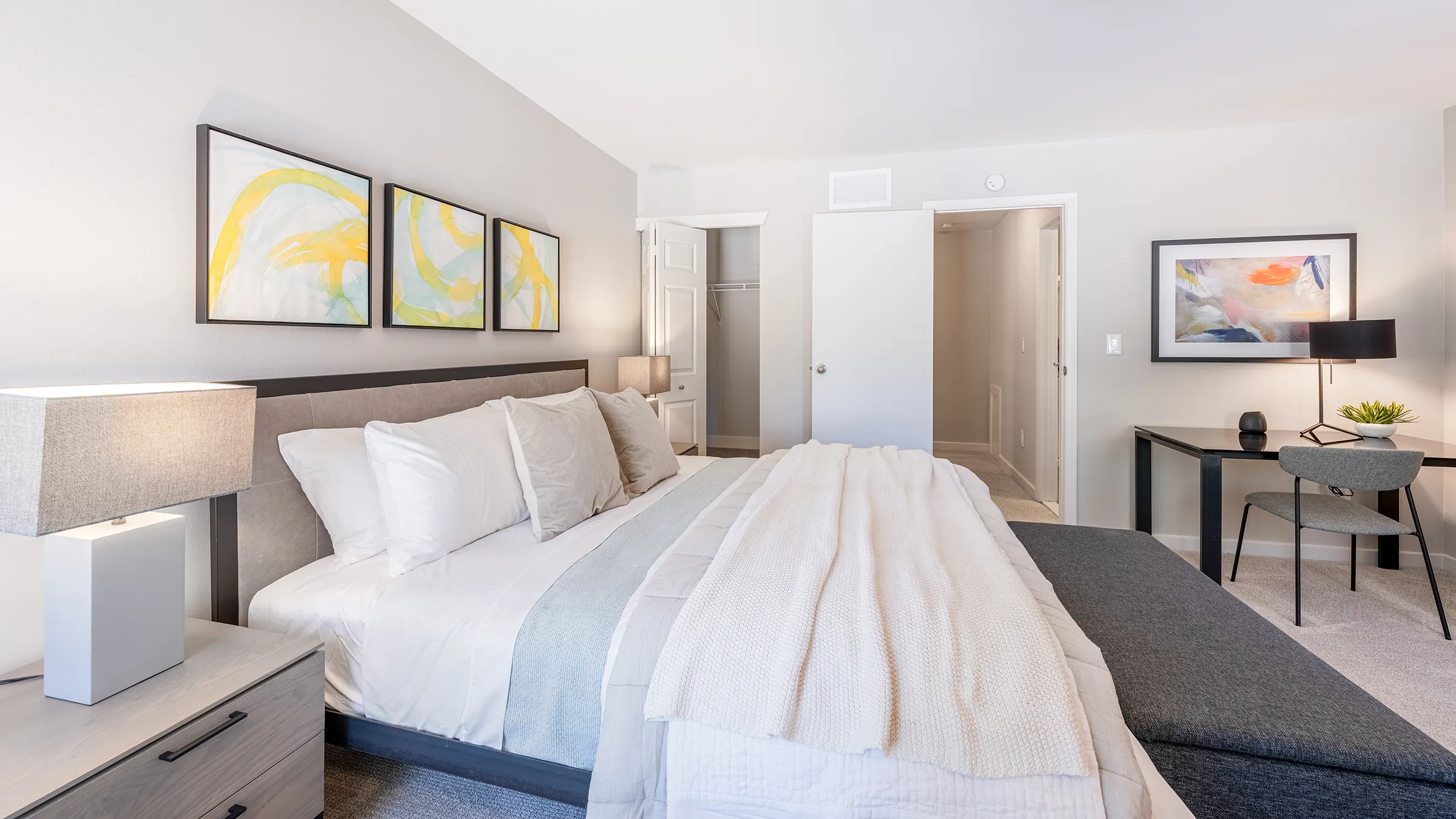 a bed with white sheets and pillows in a bedroom