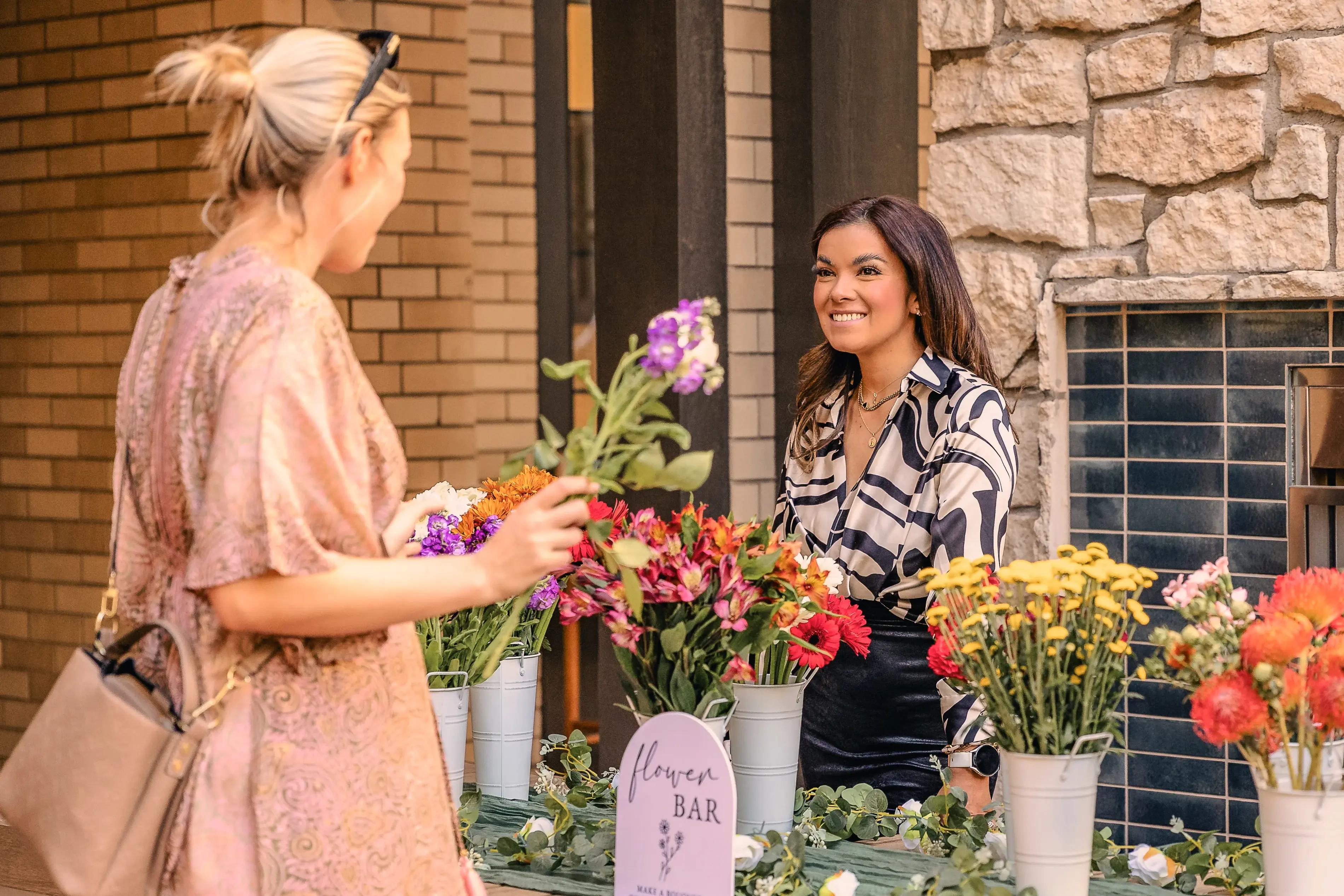 a woman standing next to another woman at a resident appreciation event at AVE Paradise Valley