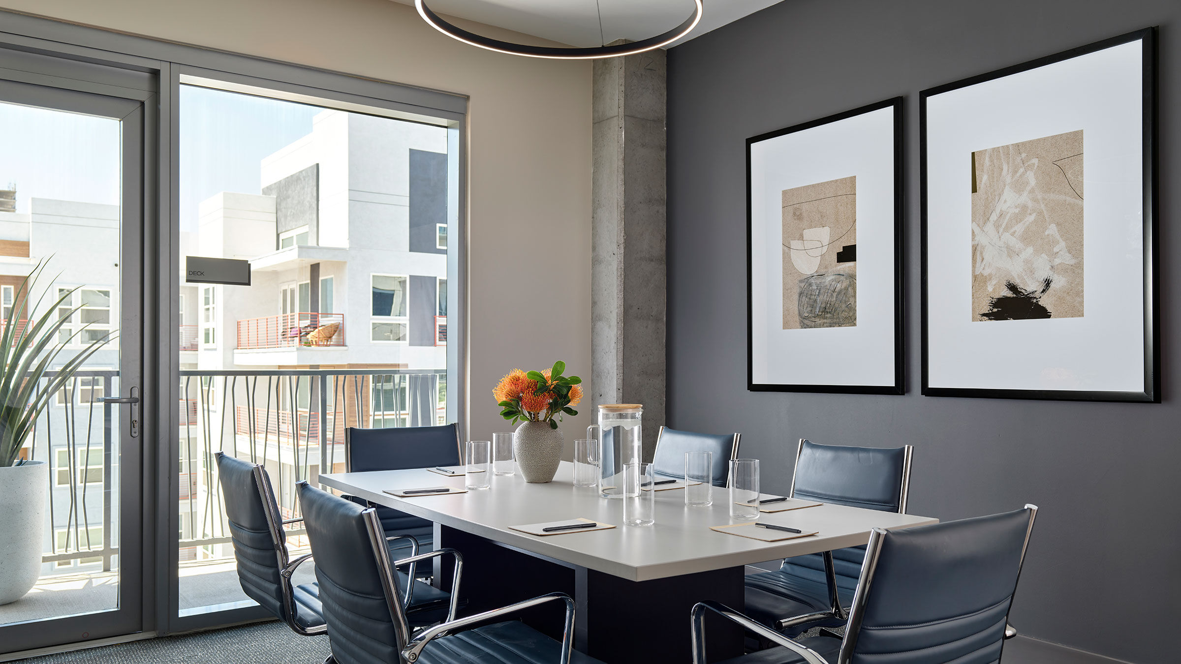 a table with chairs and a vase of flowers on it