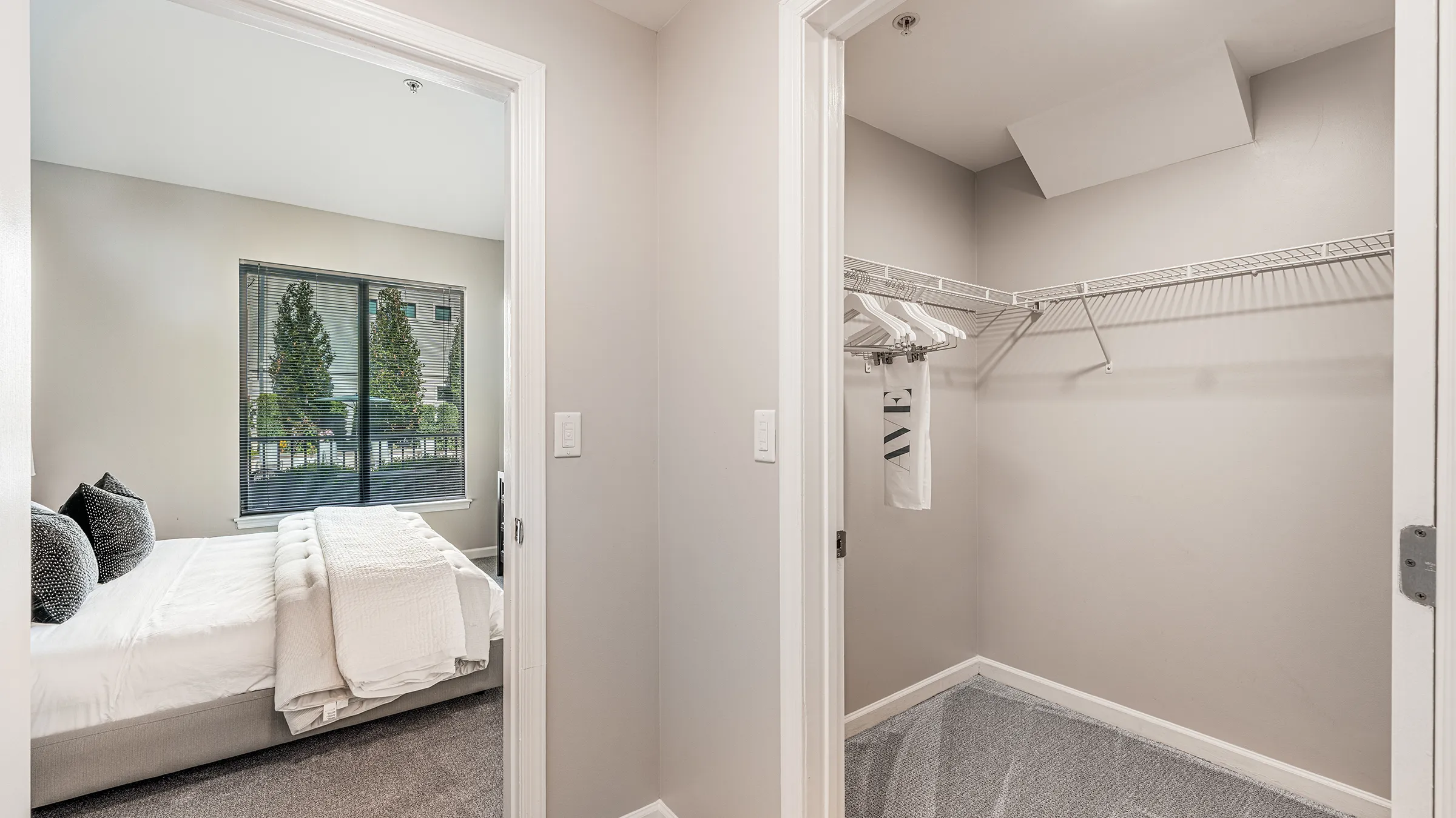 a walk-in closet with a door open and a bed
