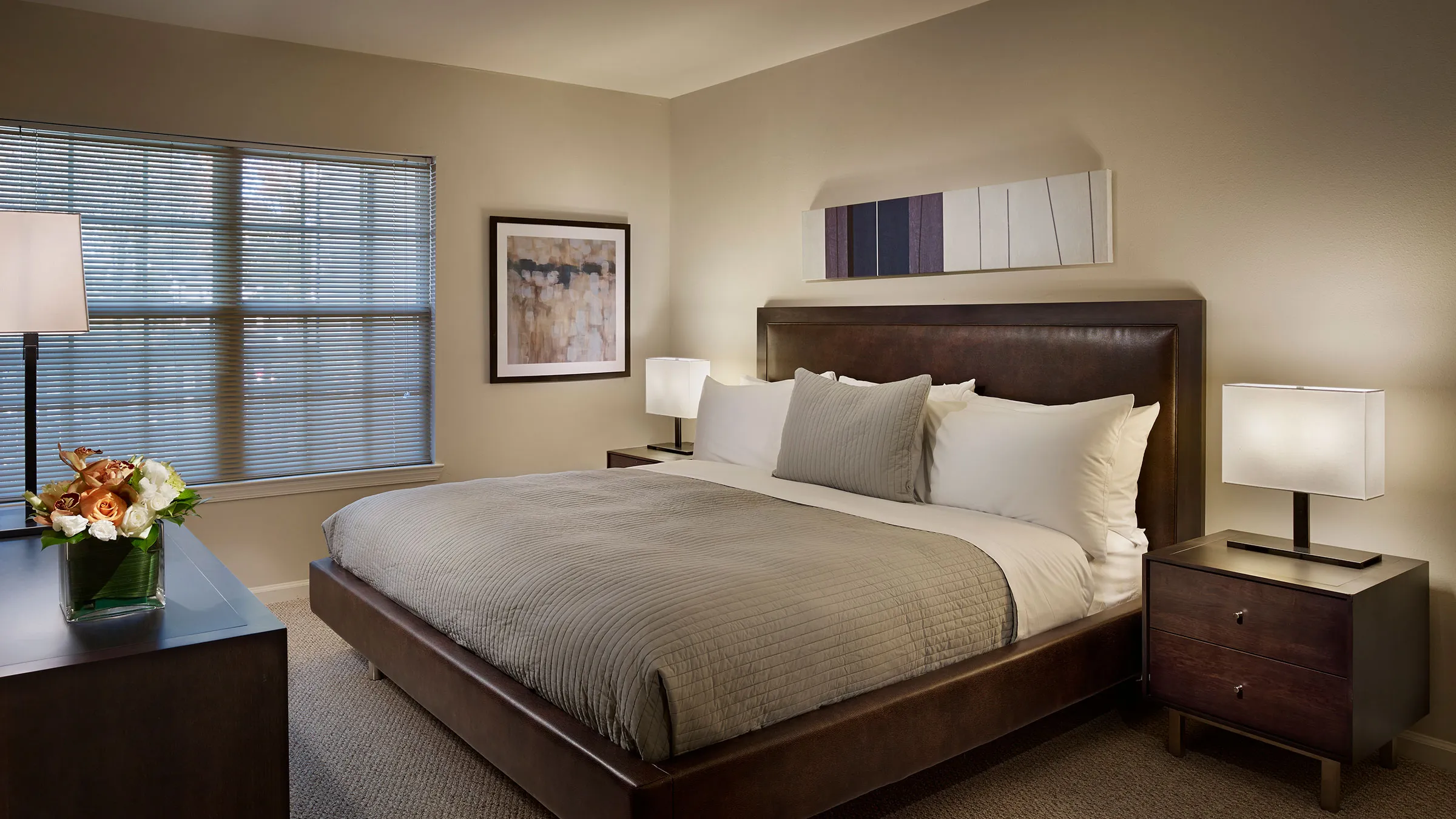 a bed with a brown headboard and a lamp