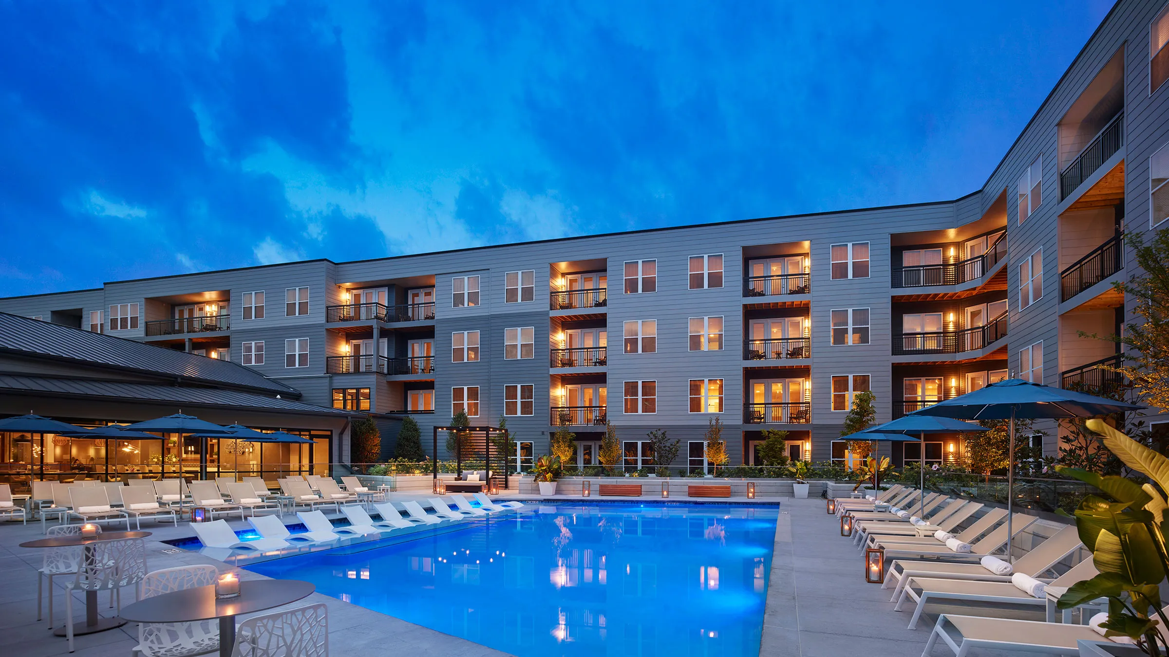a swimming pool with lounge chairs in front of a building