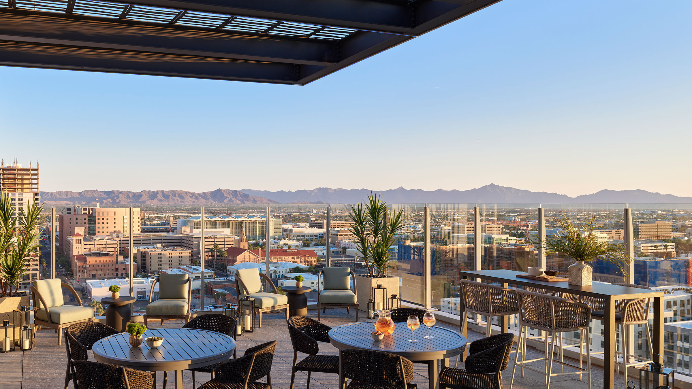 a rooftop patio with tables and chairs and a city view
