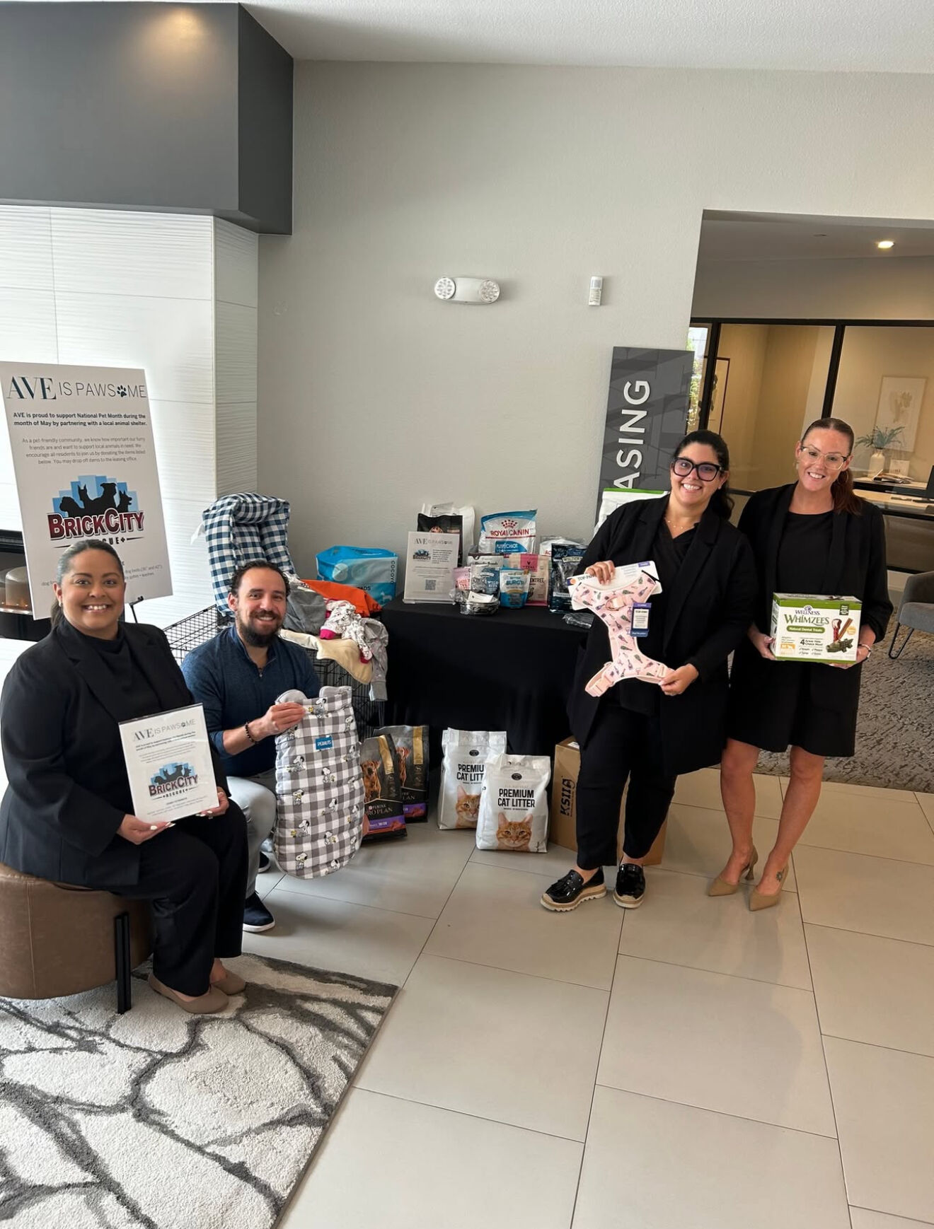 a group of people holding a dog toy and a bag of food