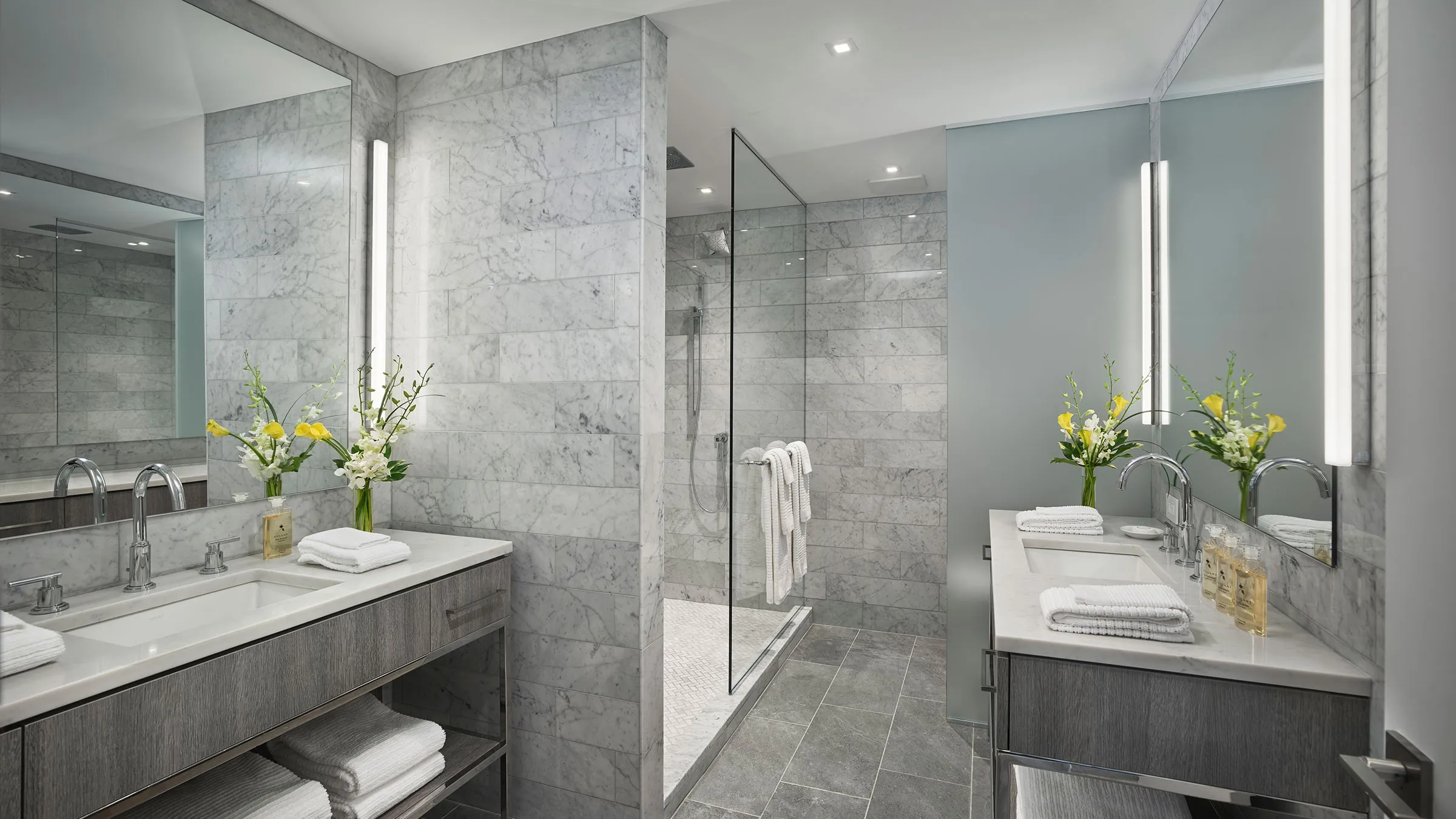 a bathroom with marble tile walls and sinks