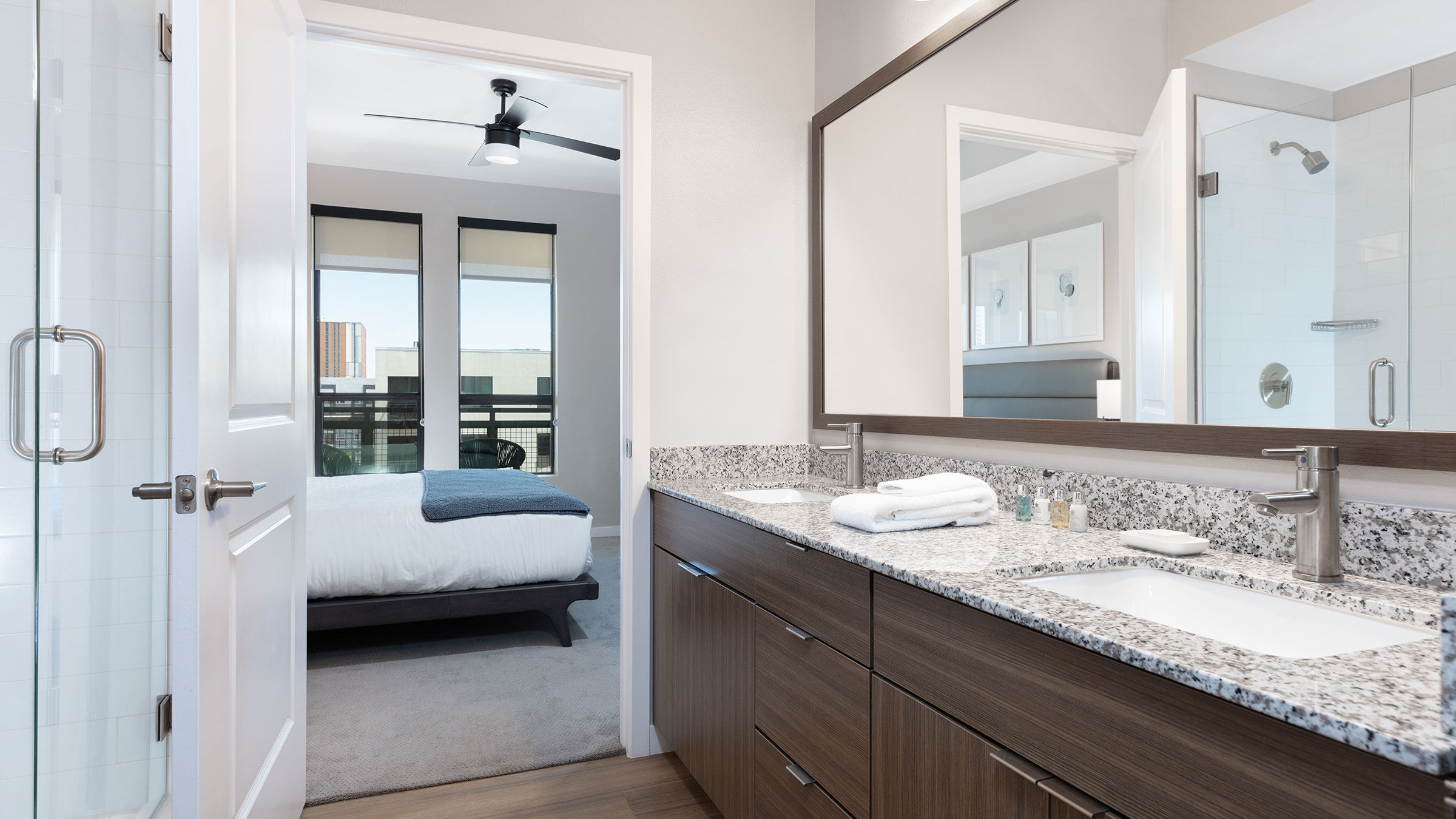 a bathroom with a double sink and a bed