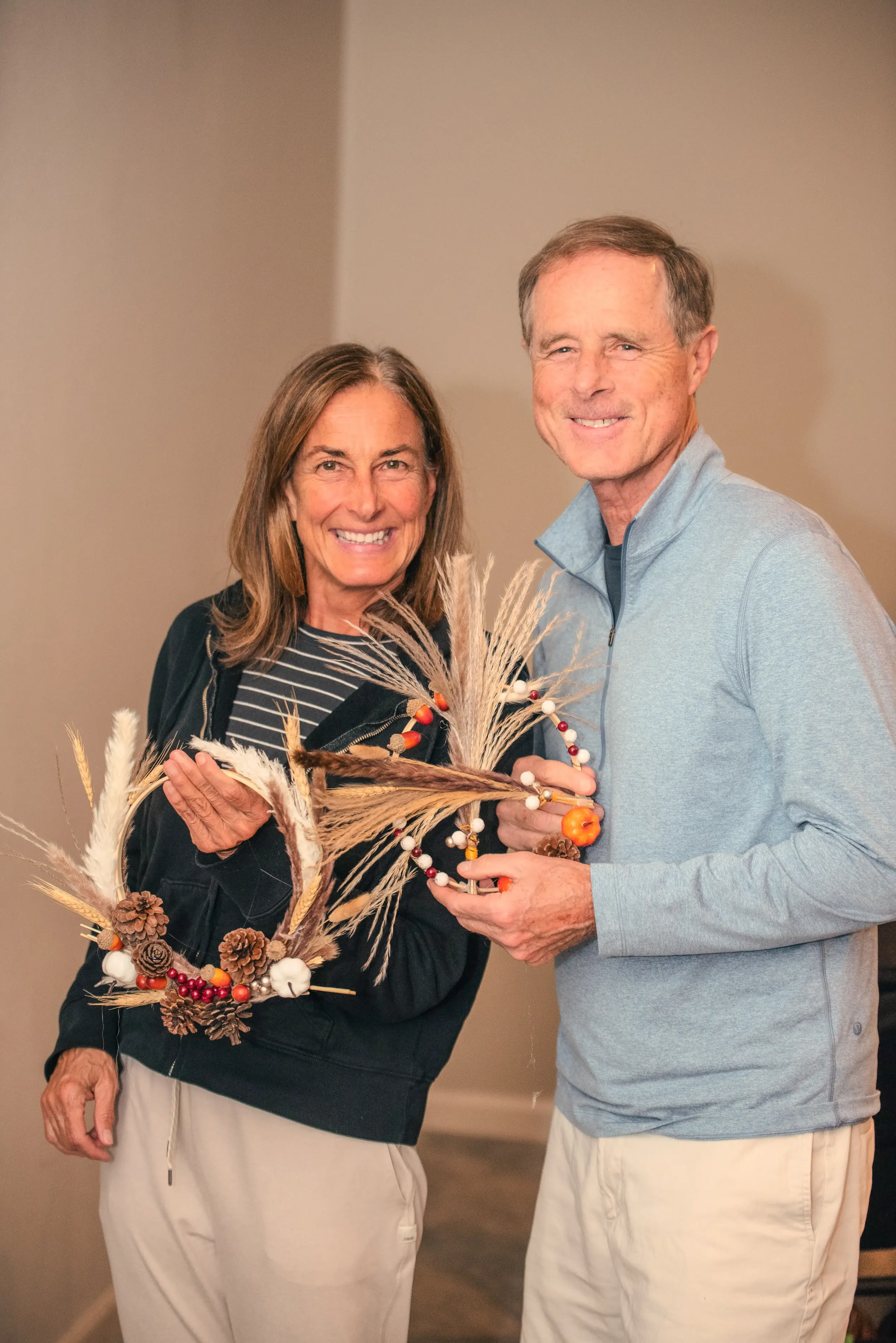 a man and woman holding a wreath