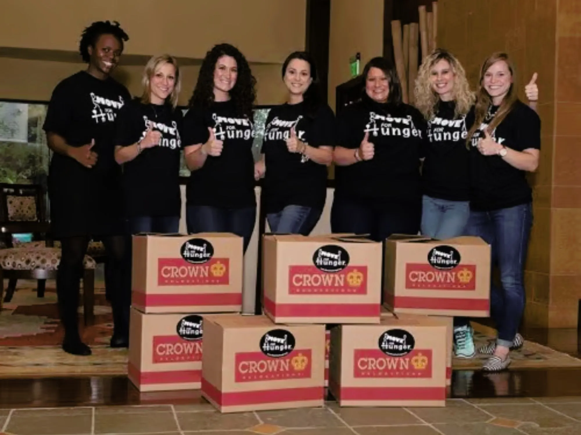 Women holding thumbs up with food donations