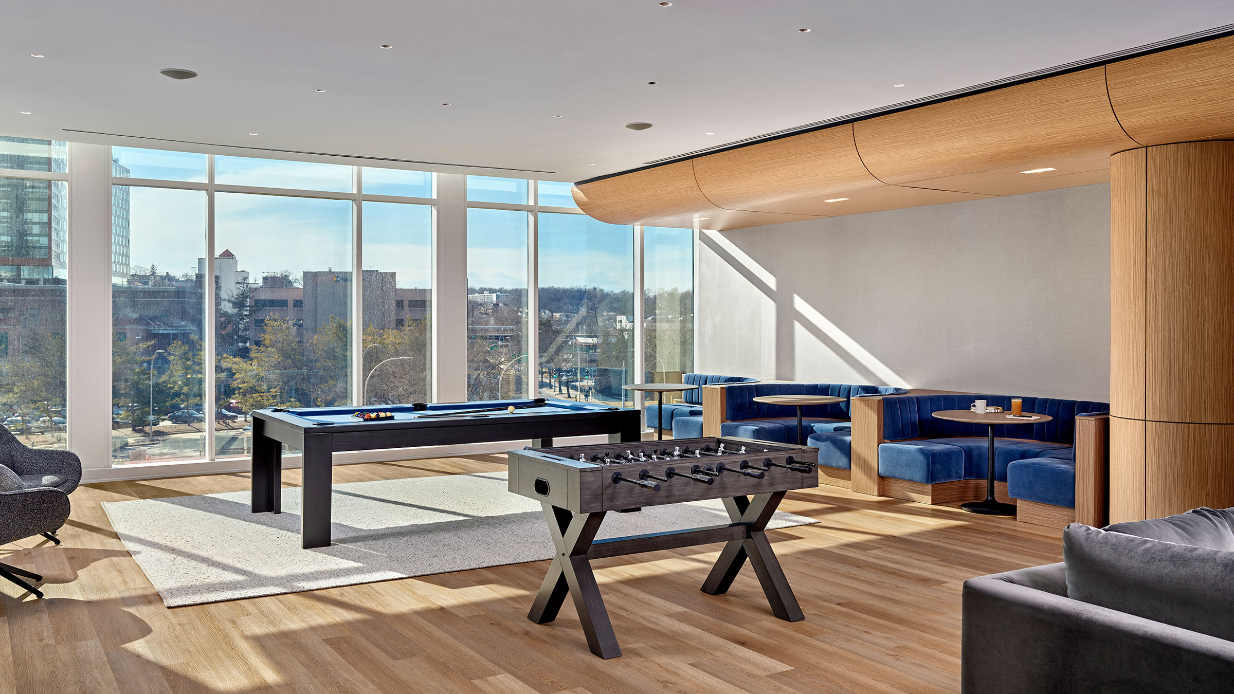 a room with a pool table and blue couches