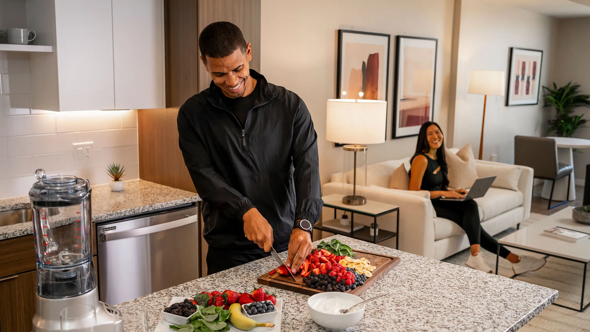 a man cutting fruit on a cutting board in a kitchen