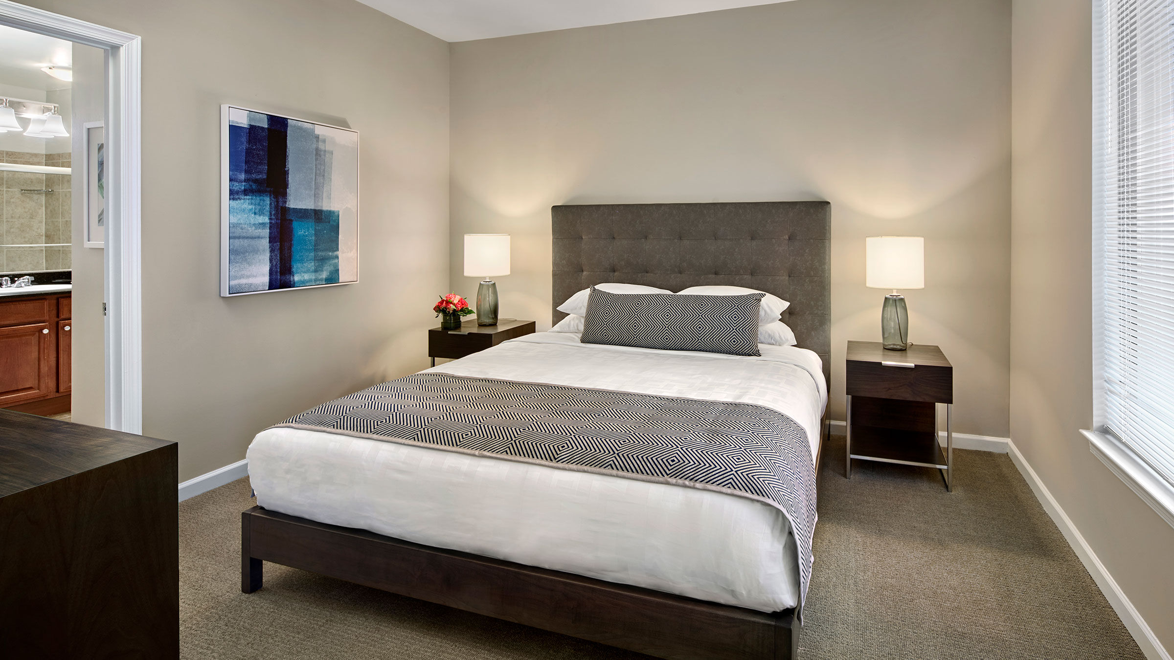 a bed with a painting on the wall