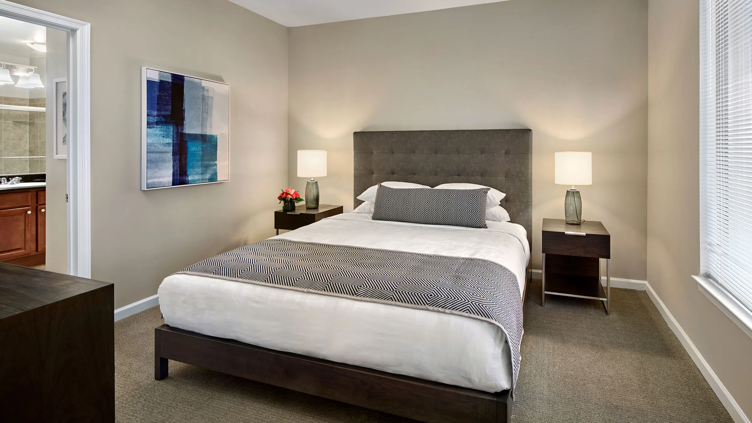 a bed with a painting on the wall