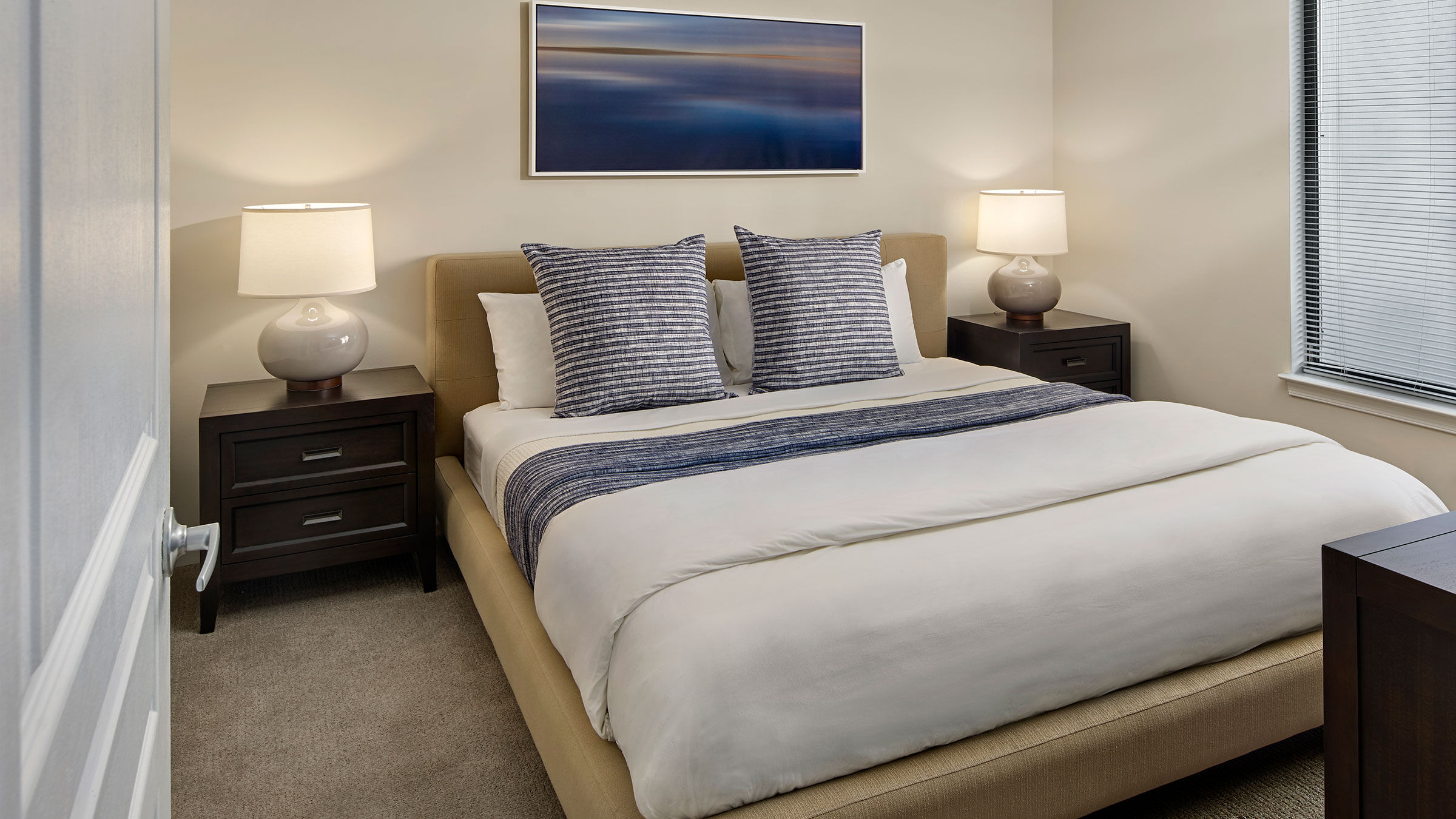 a bed with two lamps on the side