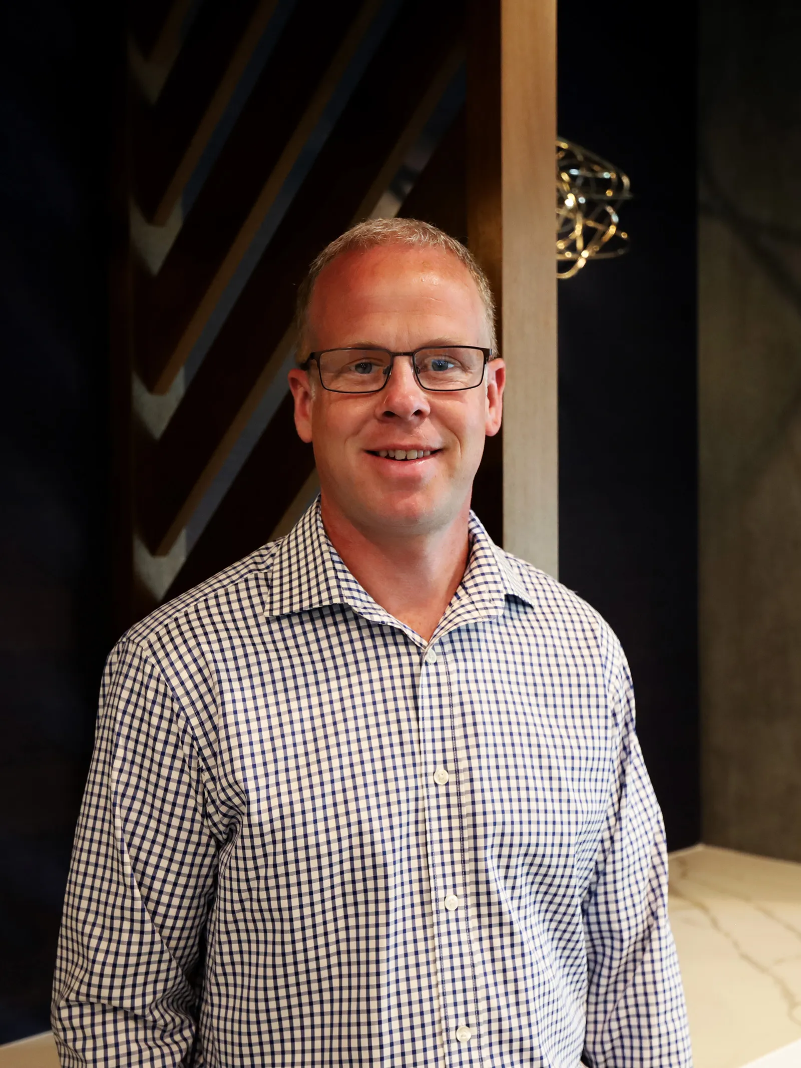 a man wearing glasses and a plaid shirt