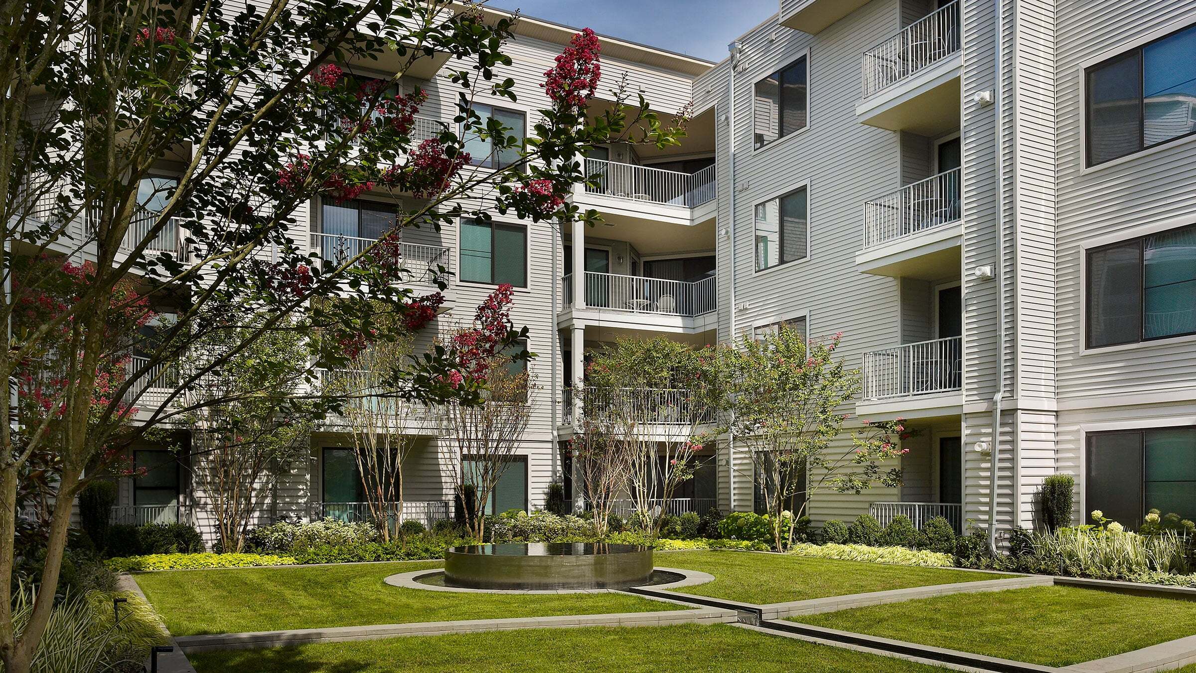 a courtyard of a building with trees and a fountain