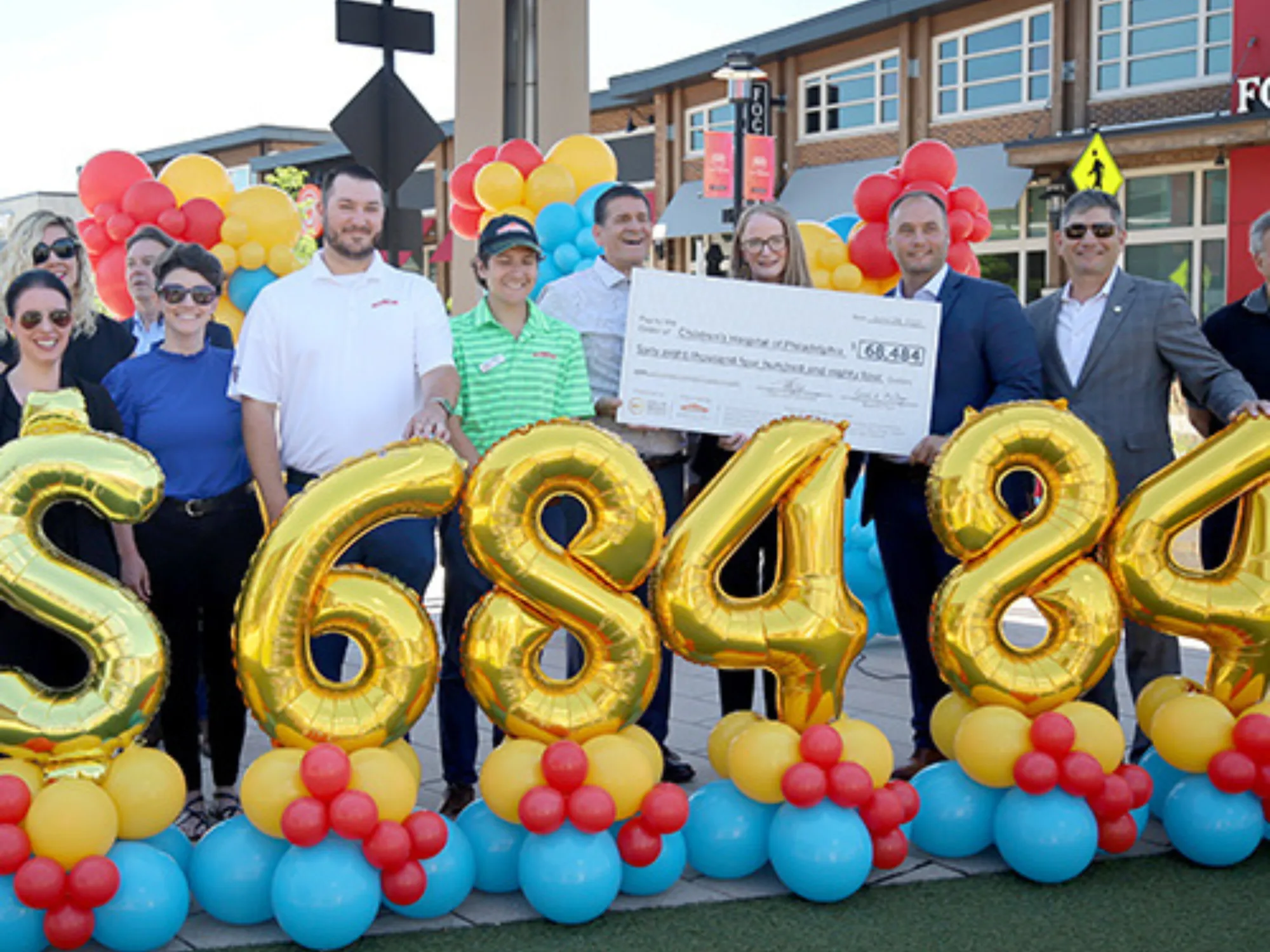 a group of people holding a check and balloons