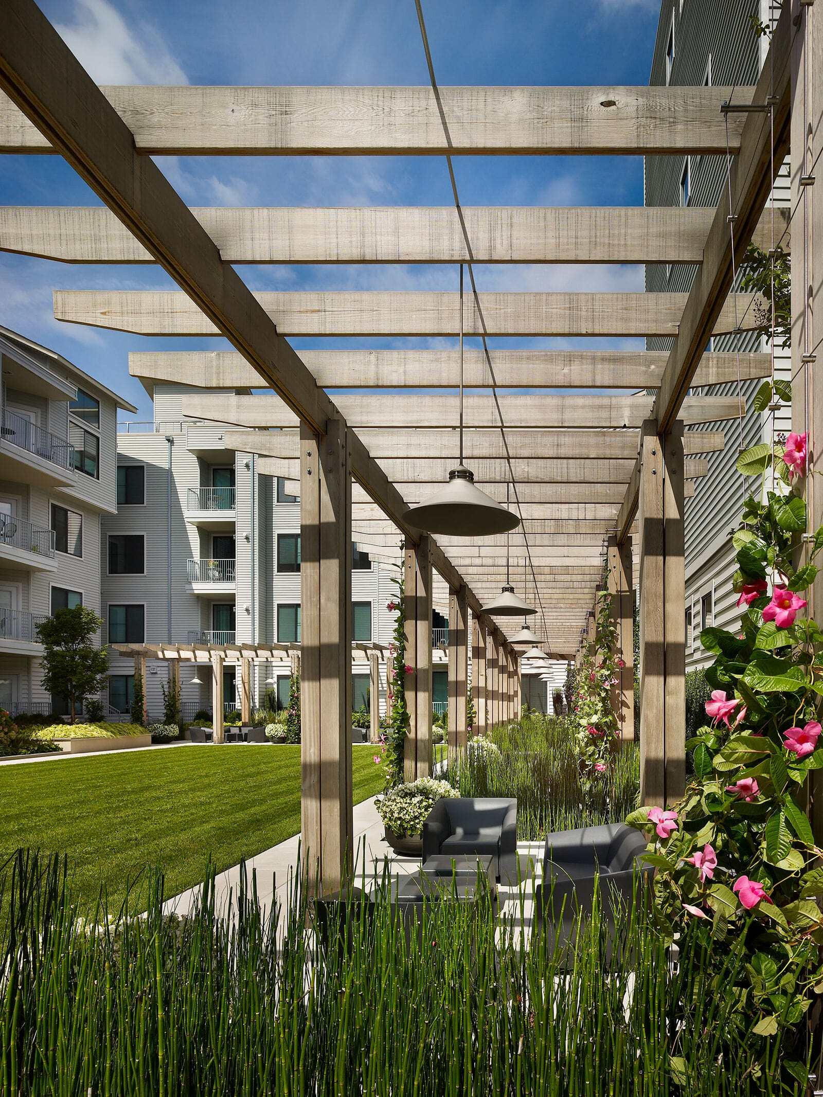 a covered area with a patio and grass
