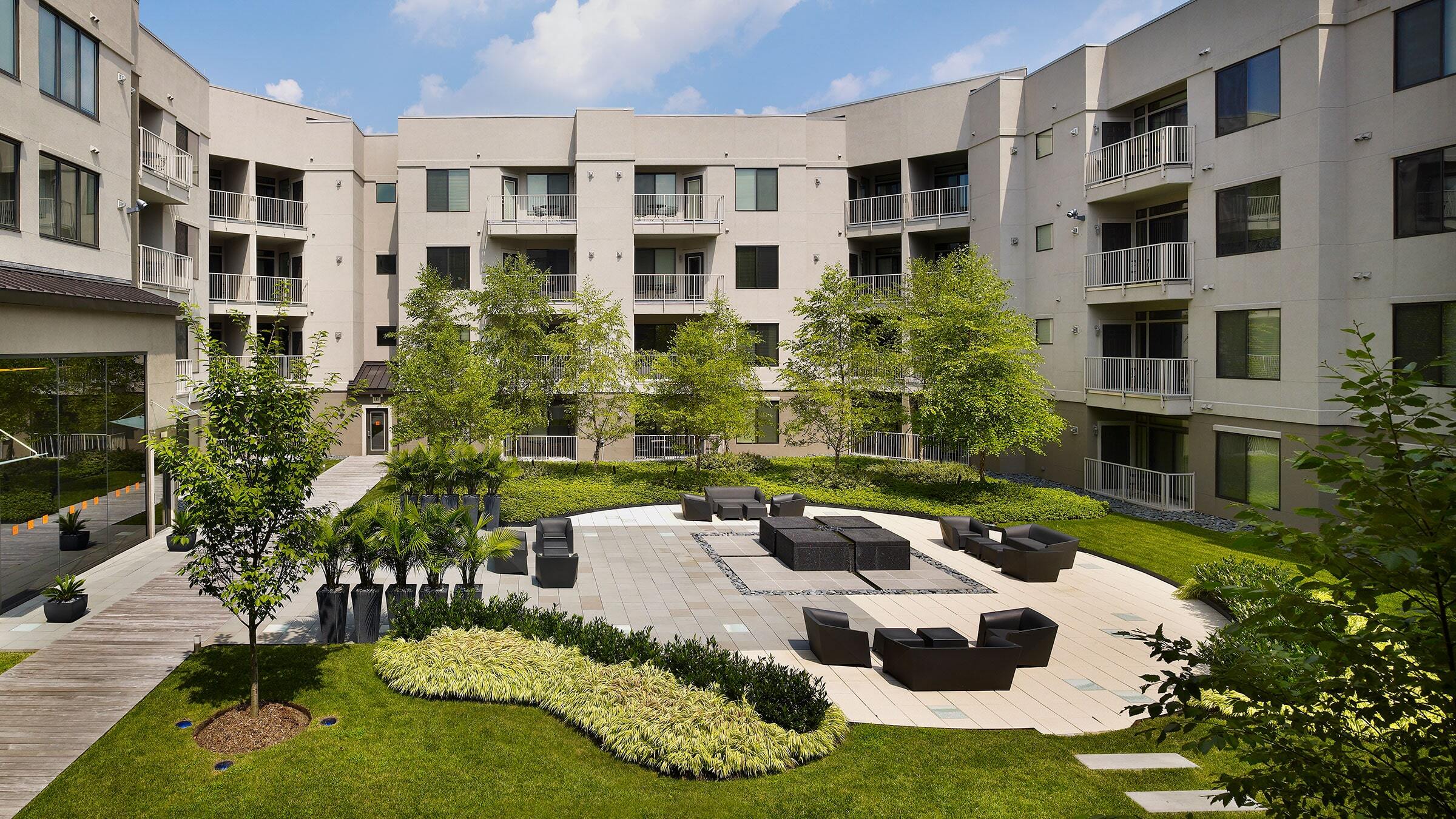 a courtyard with a large building and trees
