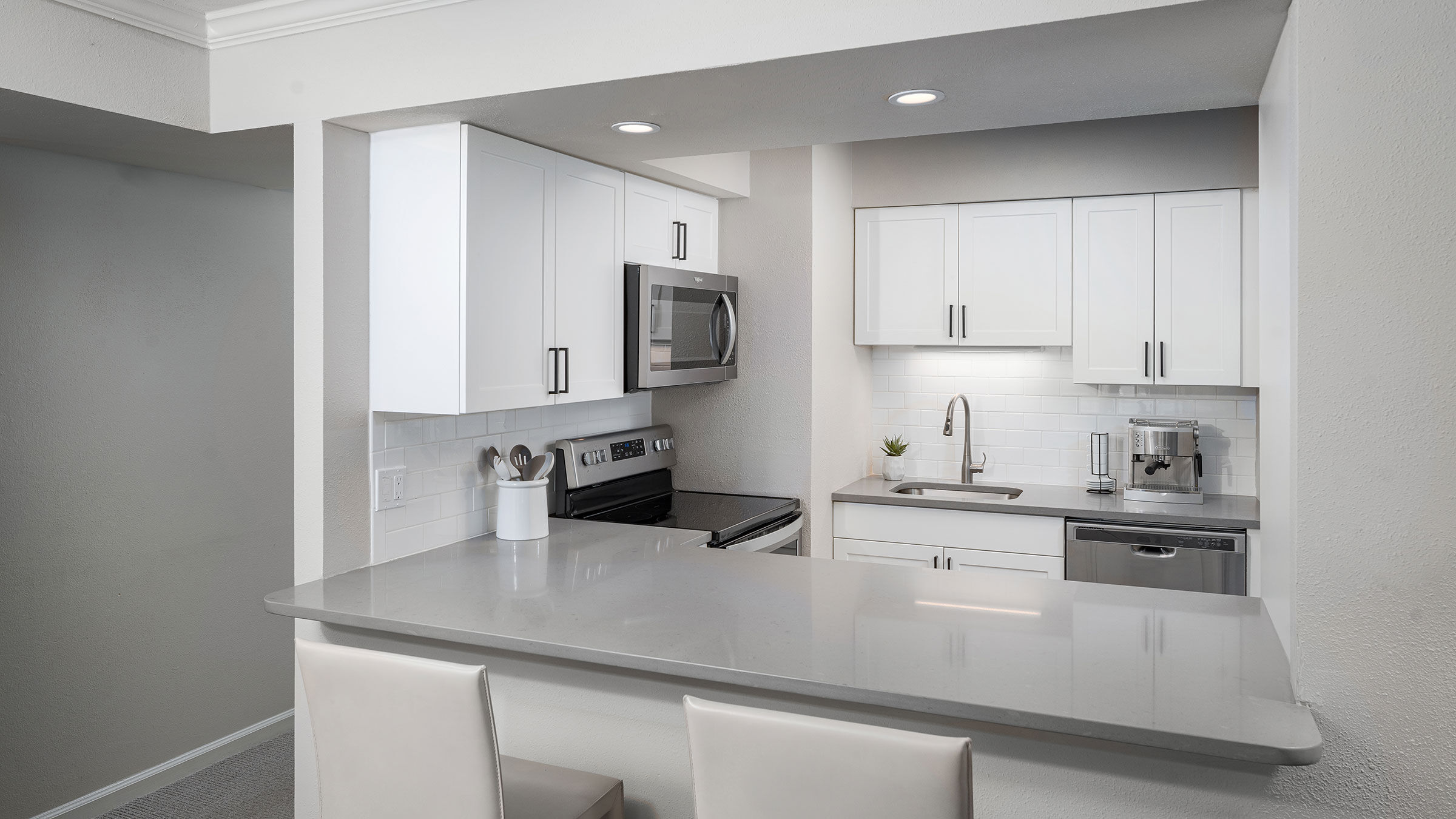 a kitchen with white cabinets and a white countertop
