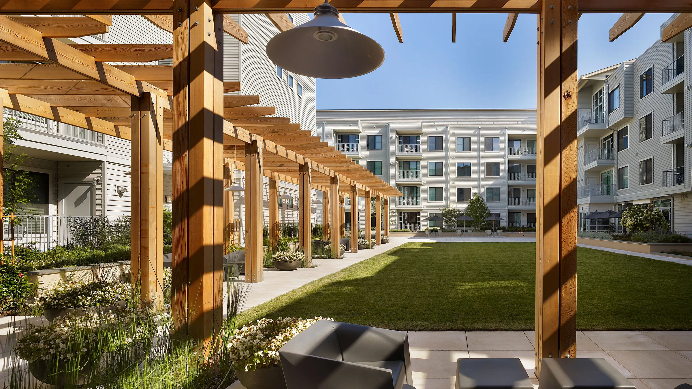 a patio with a large lawn and a building