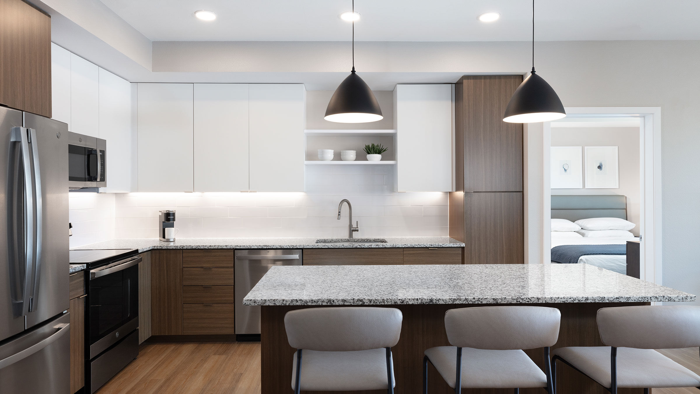 a kitchen with a marble countertop and chairs