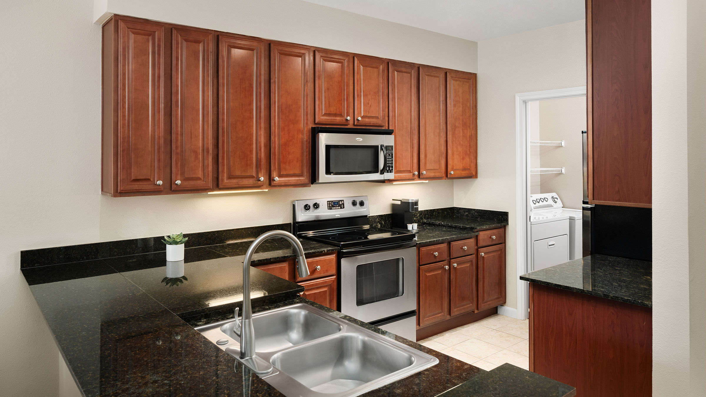 a kitchen with black granite counter tops and stainless steel appliances