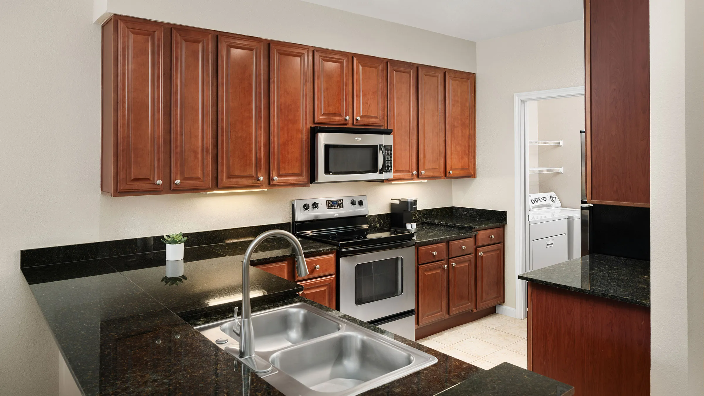 a kitchen with black granite counter tops and stainless steel appliances