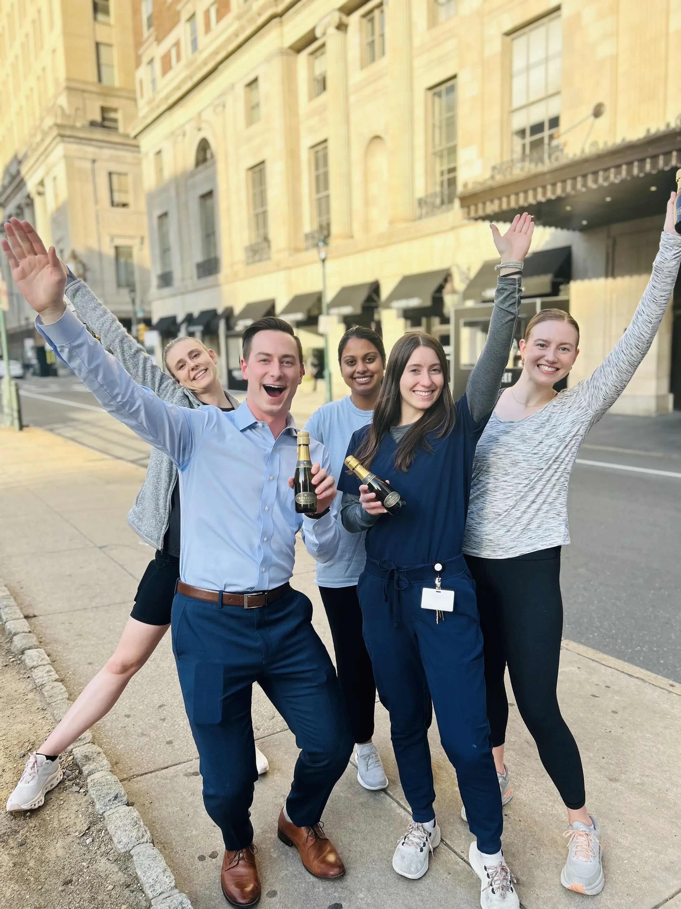a group of medical residents in blue scrubs posing for a photo