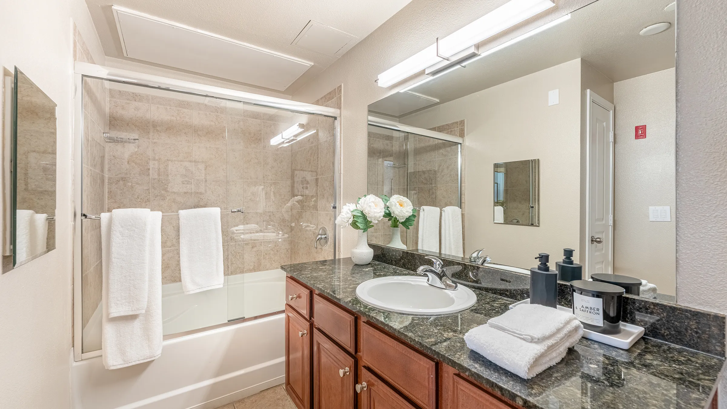 a bathroom with a glass shower door and sink