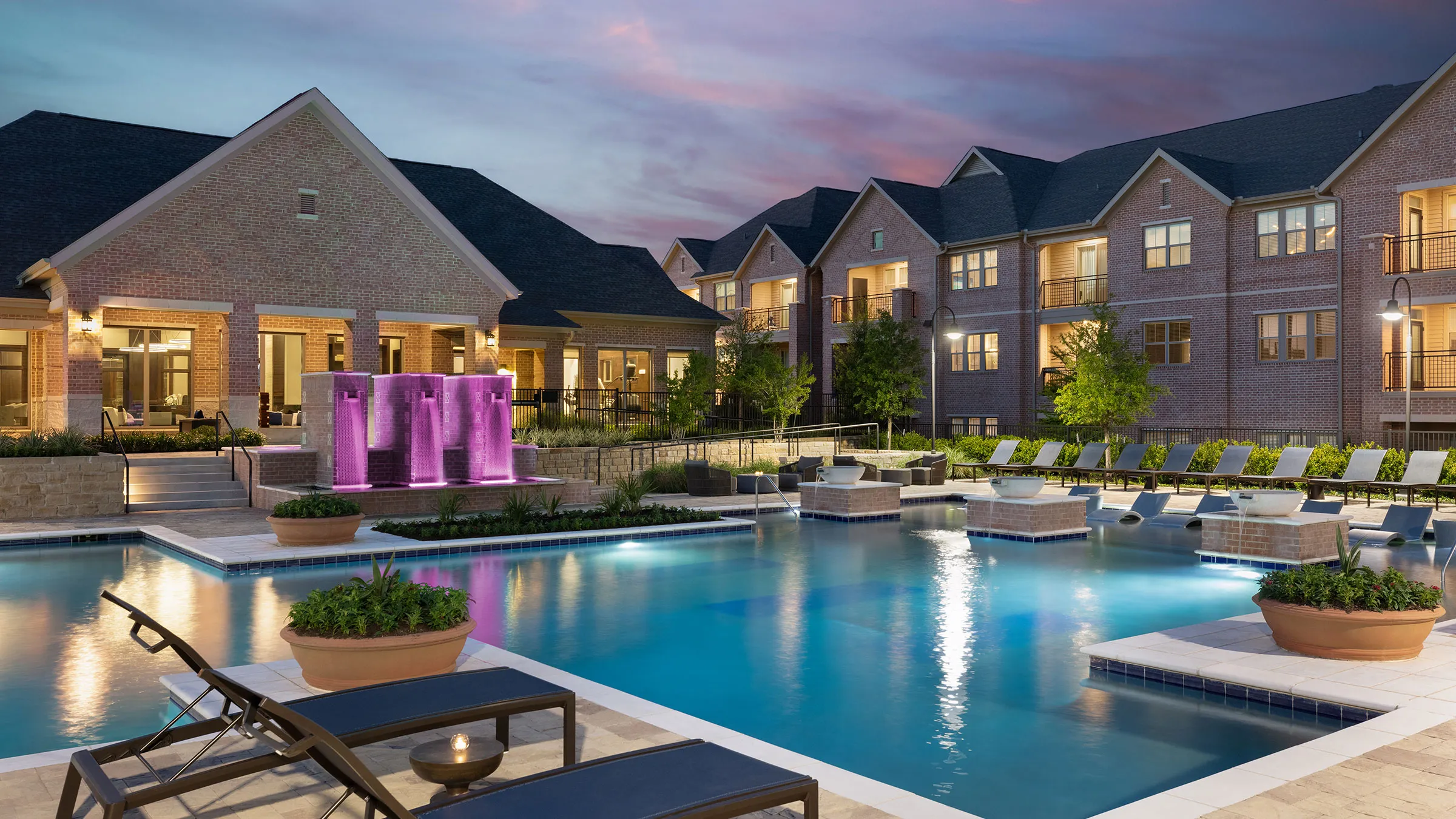 a pool with a purple fountain and a building in the background