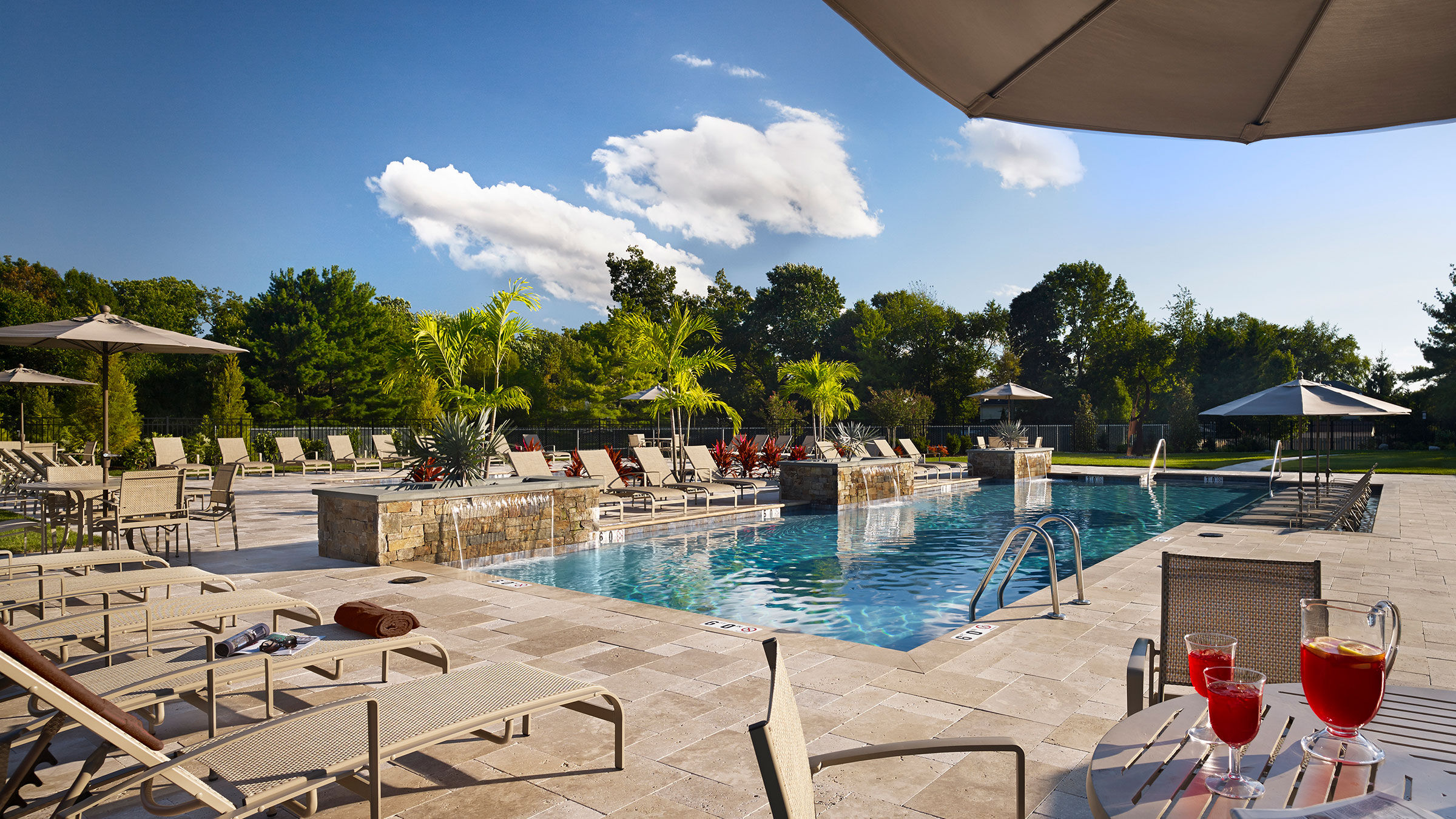 a pool with chairs and a stone patio
