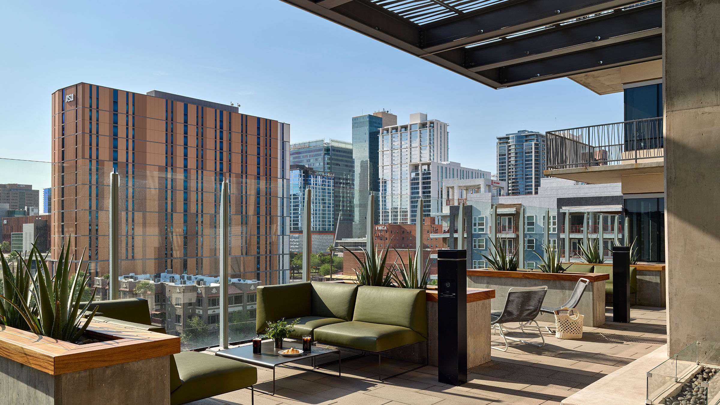 a rooftop patio with a green couch and chairs