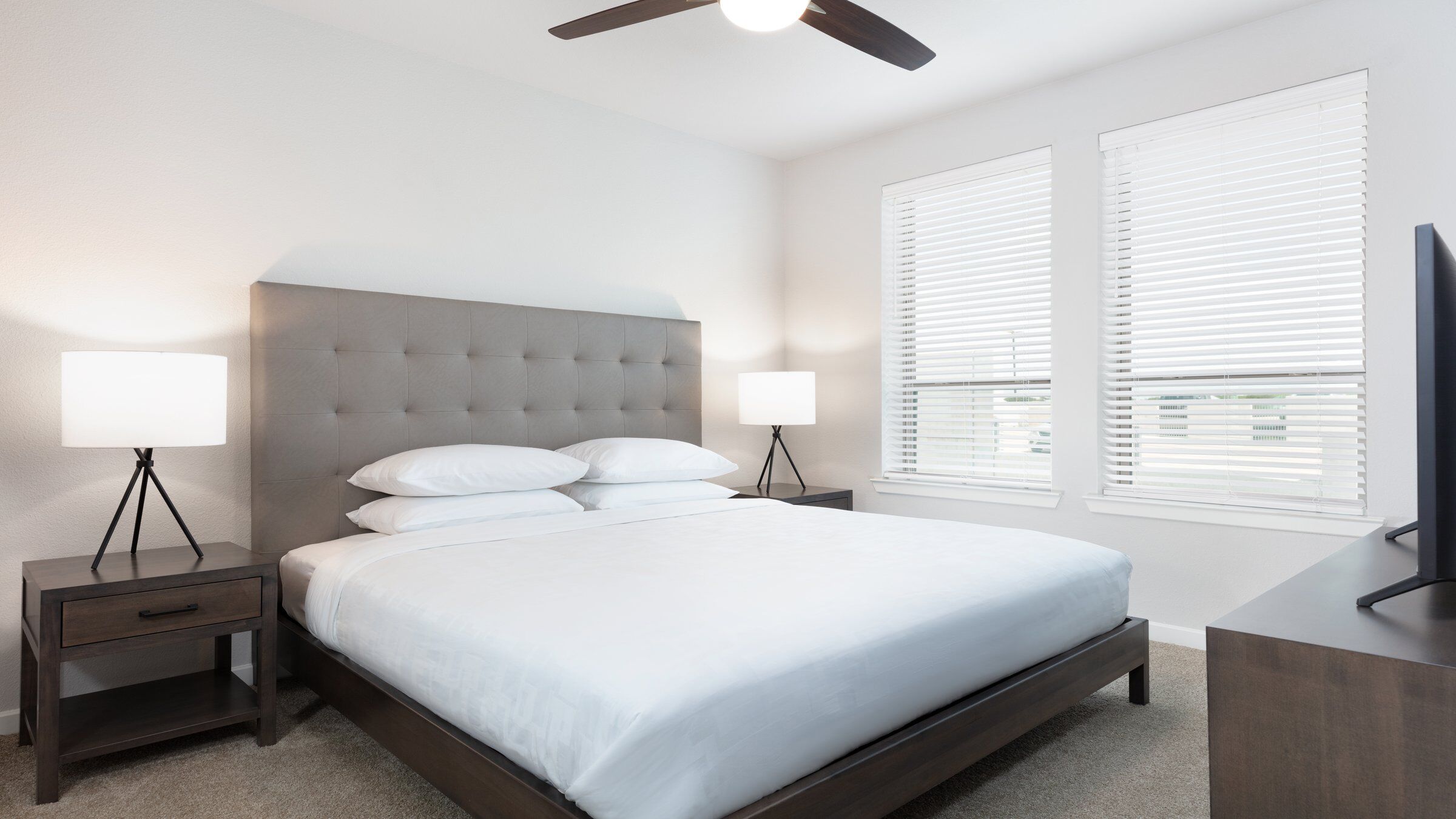 a bed with a fan and a window